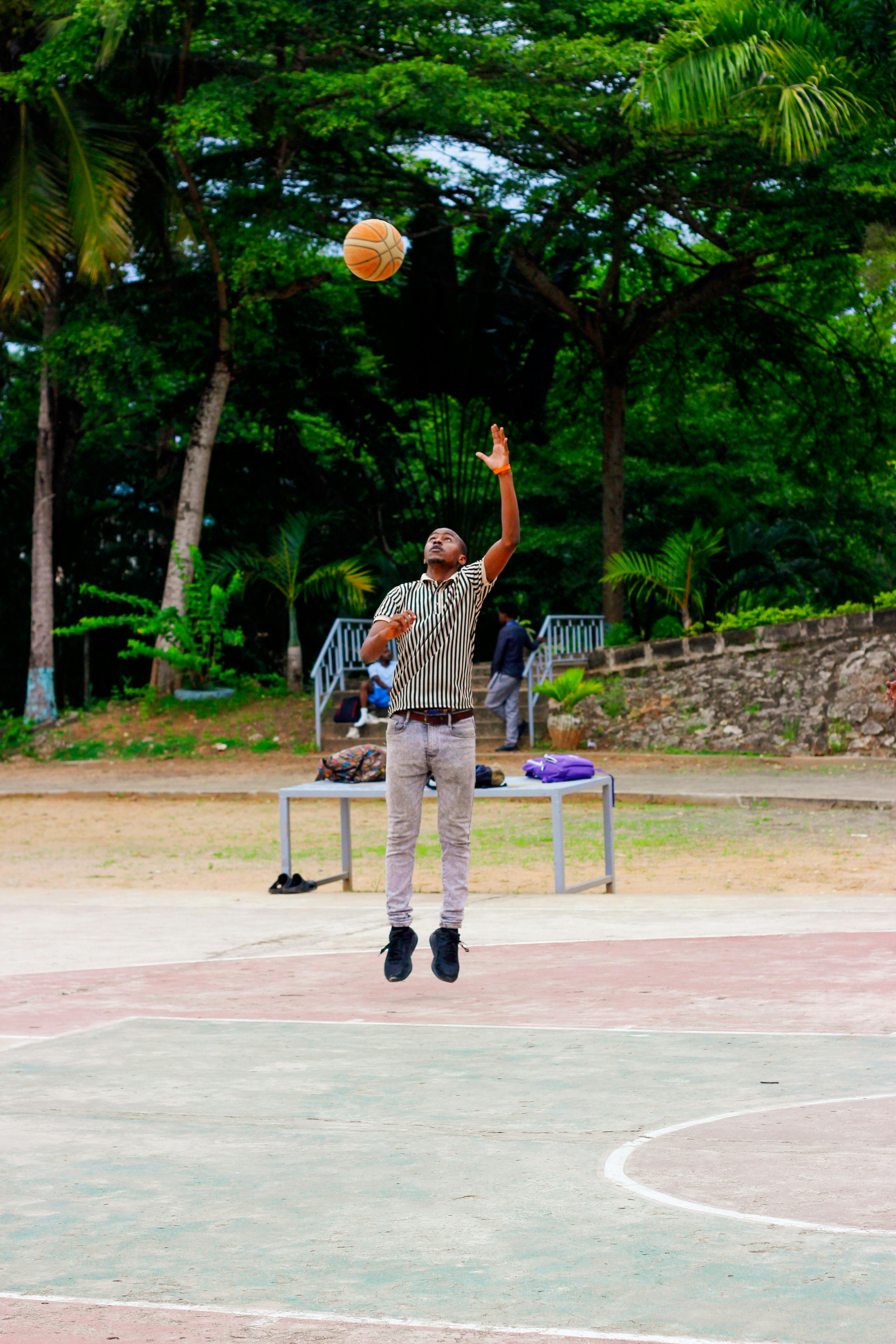 Man Jumping to Shoot Basketball Outdoors