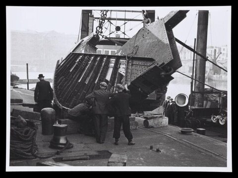 Workers Assembling Ship Hull at Dock