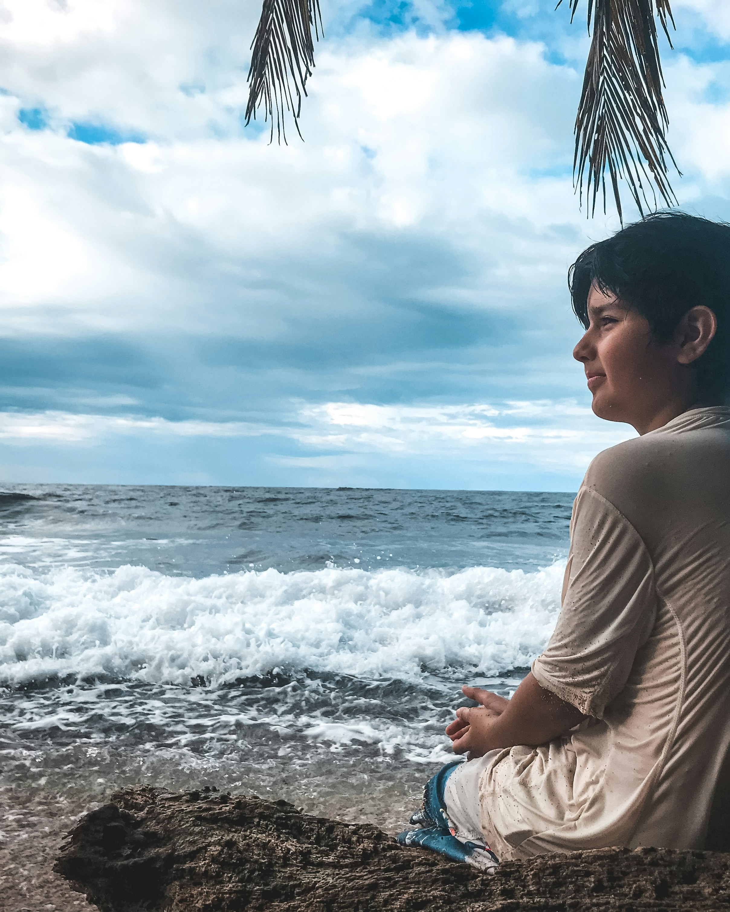 Boy Looking At Ocean At Beach