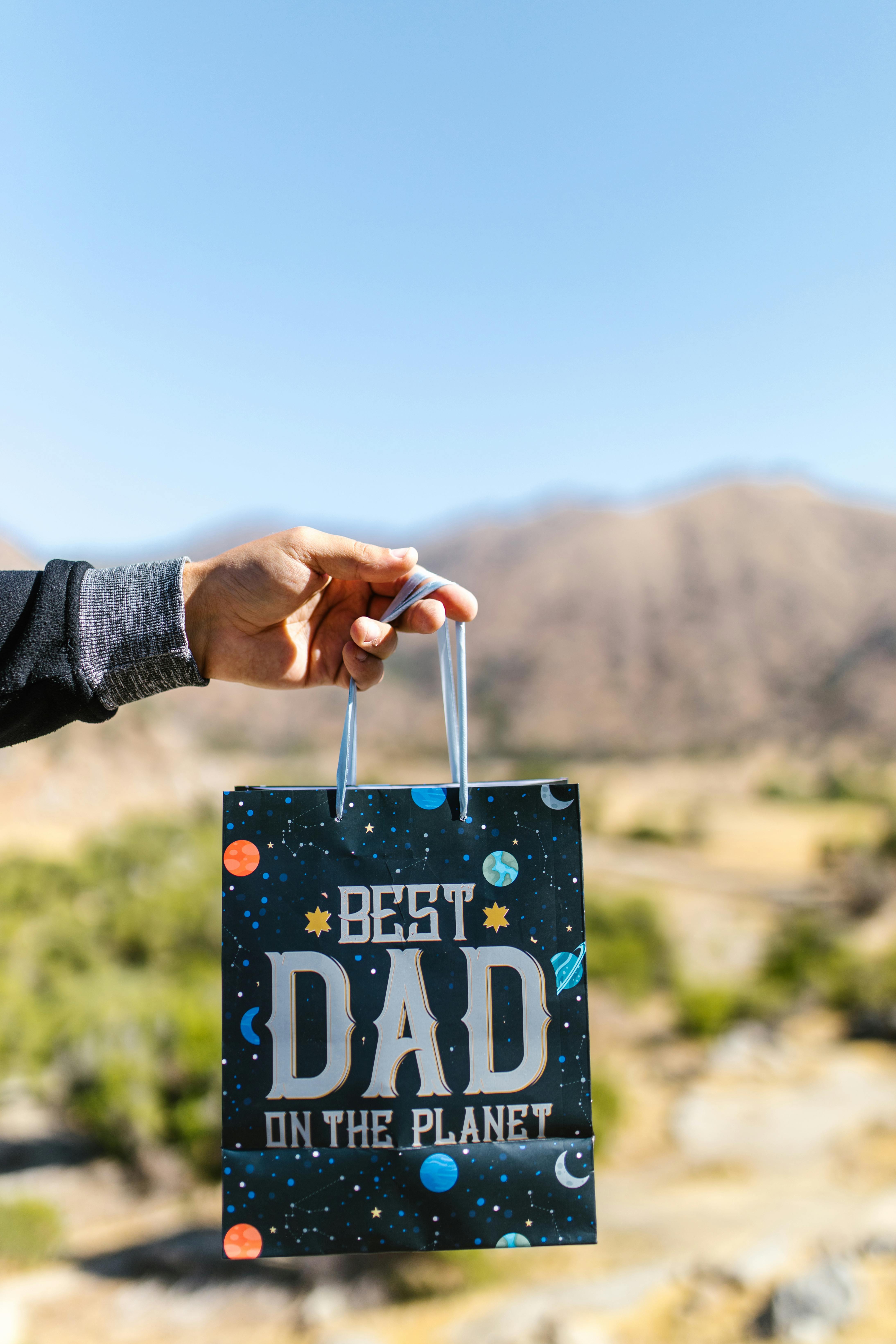 Hand Holding Best Dad Gift Bag Outdoors