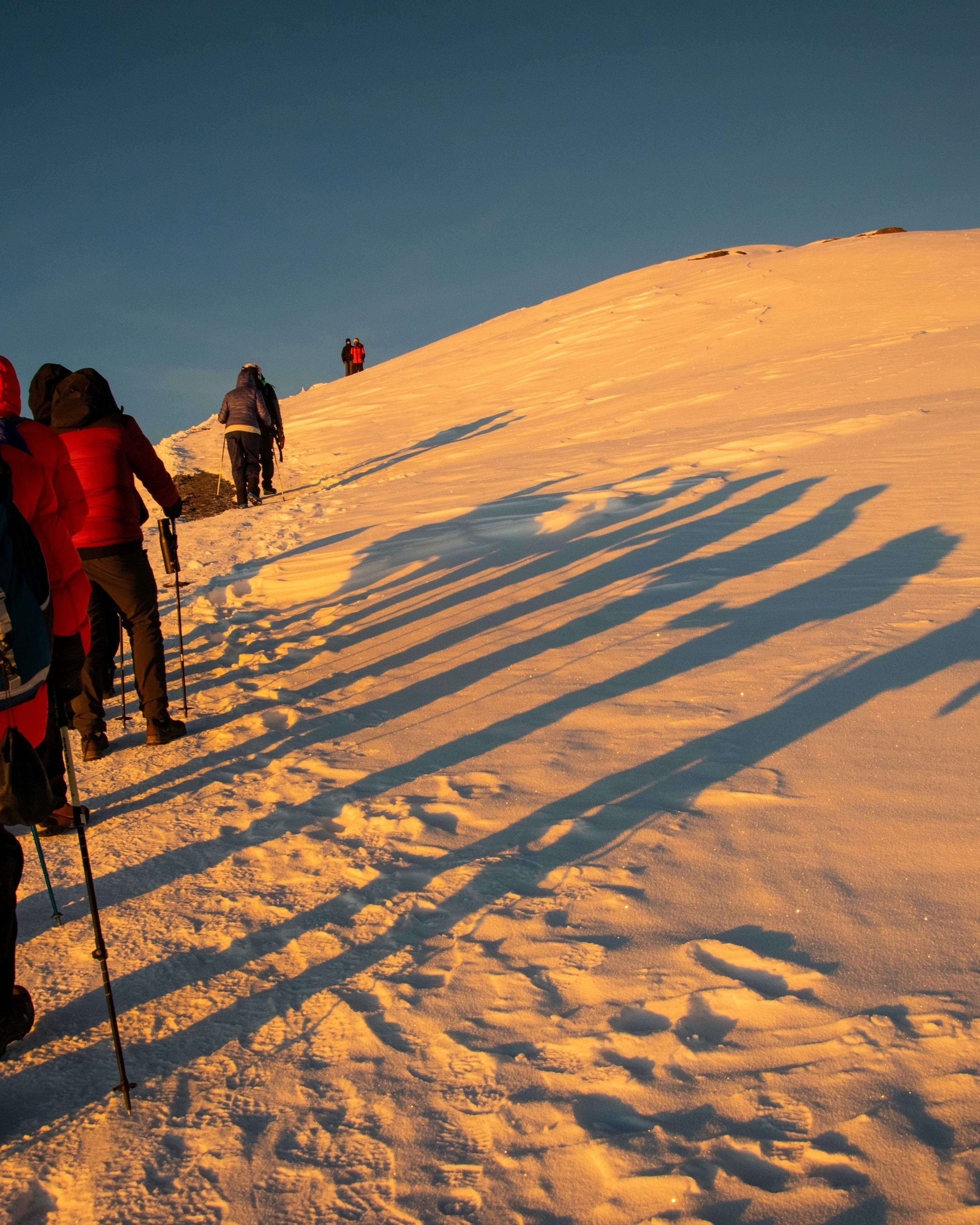 Hikers Climbing Snowy Mountain Slope