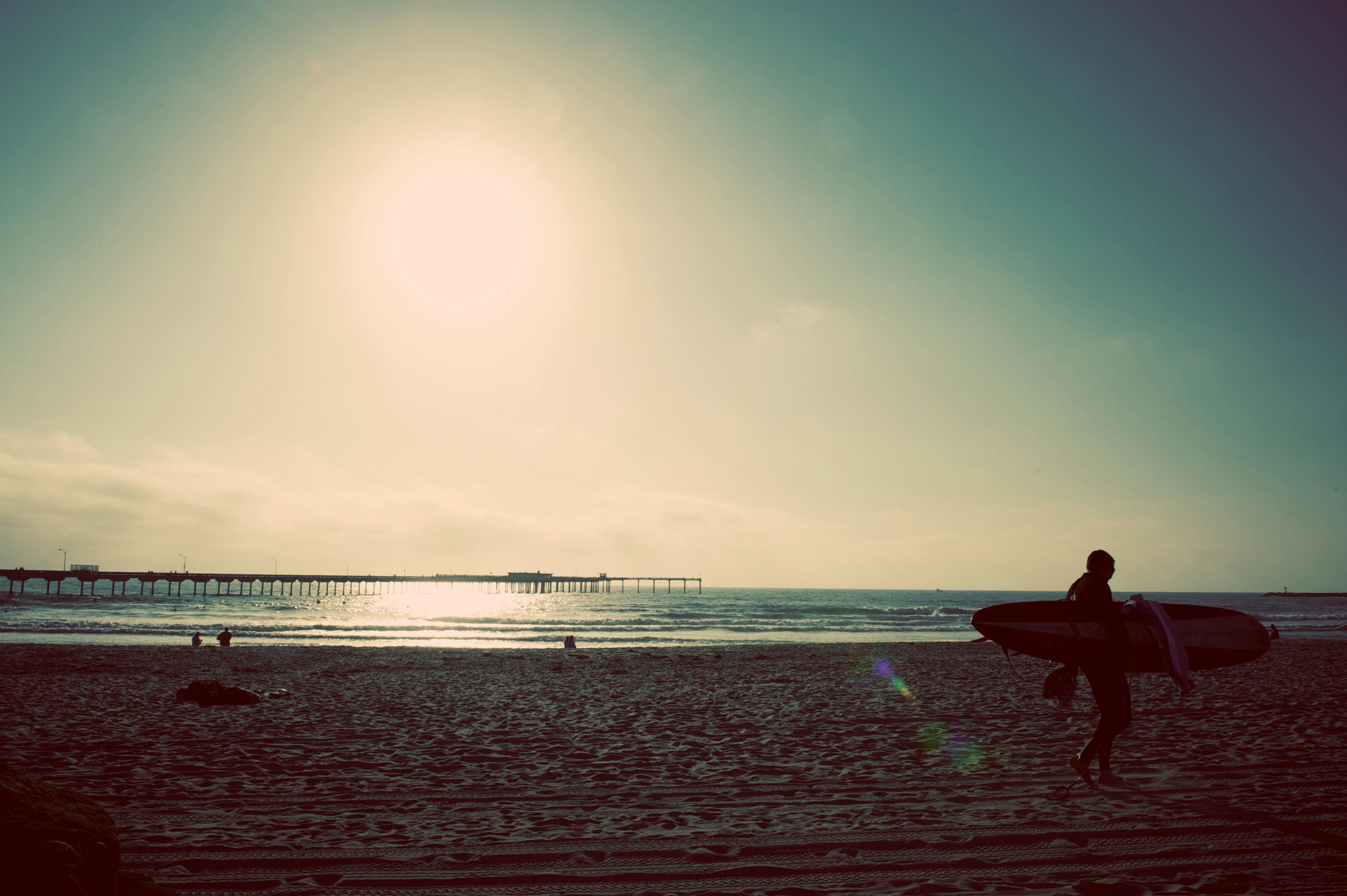 Surfer Walking on Beach at Sunset