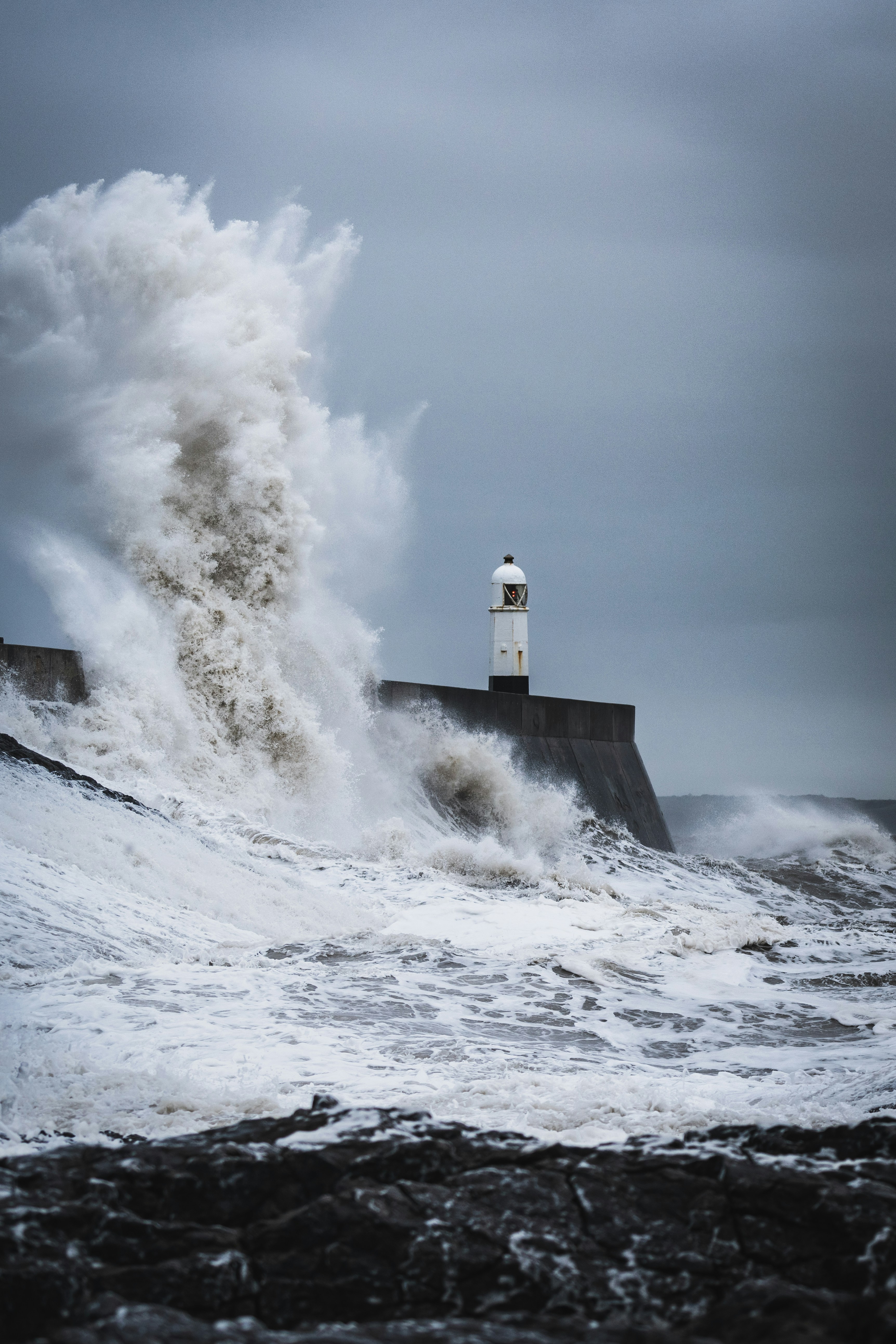 Giant Wave Crashes Against Lighthouse Breakwater