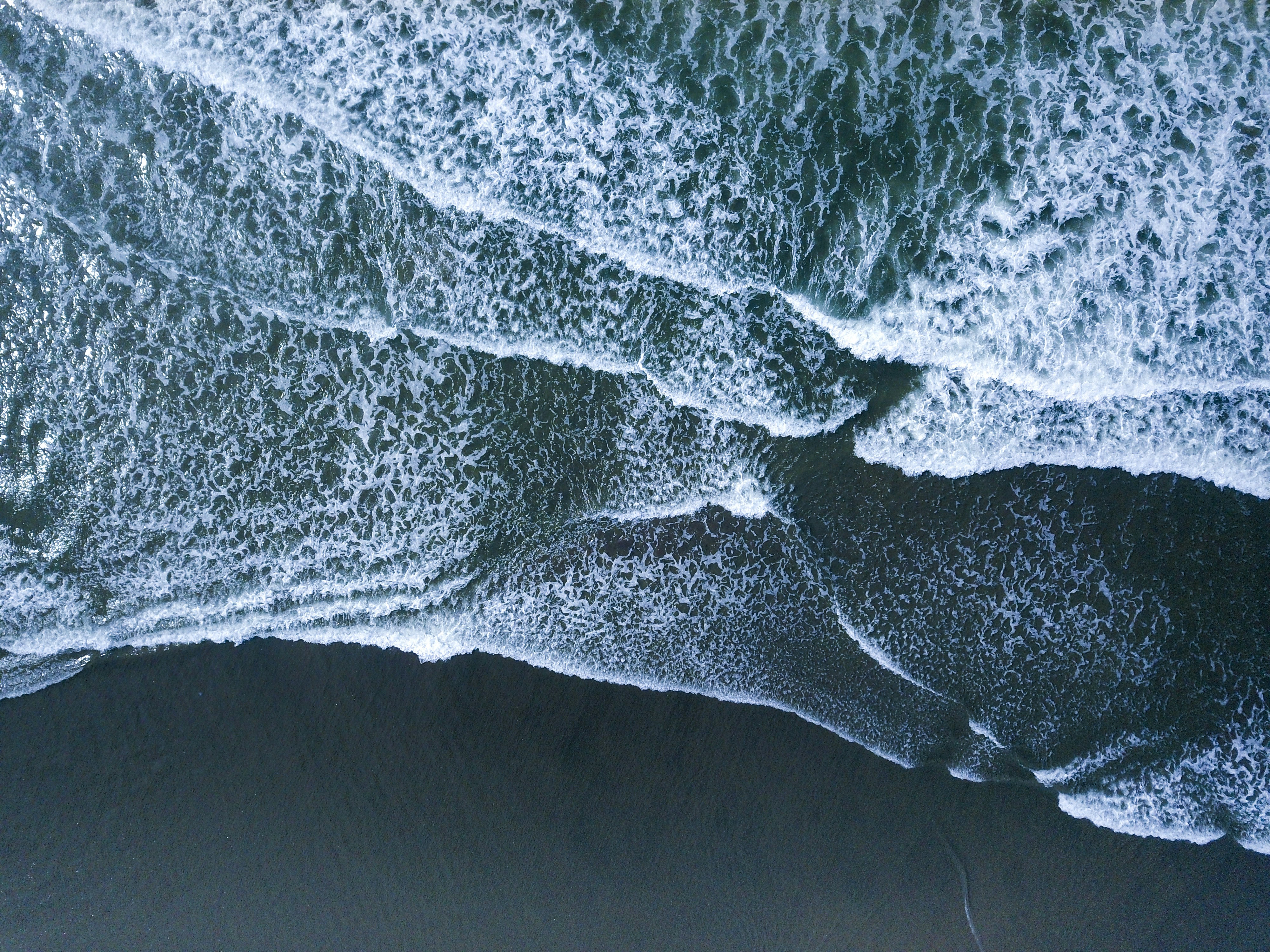Aerial View of Waves on Black Sand Beach