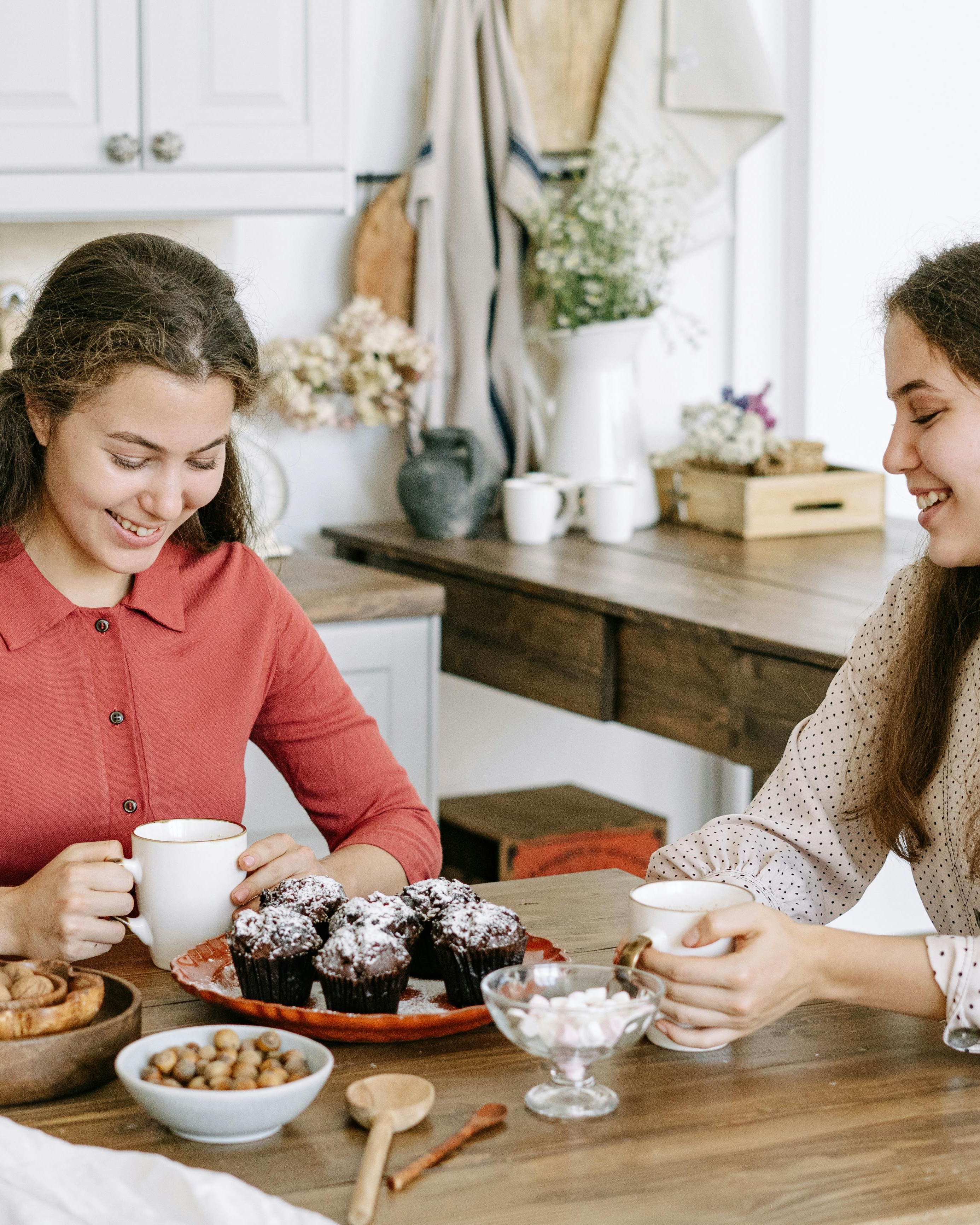 Two Women Sharing Snacks In Kitchen