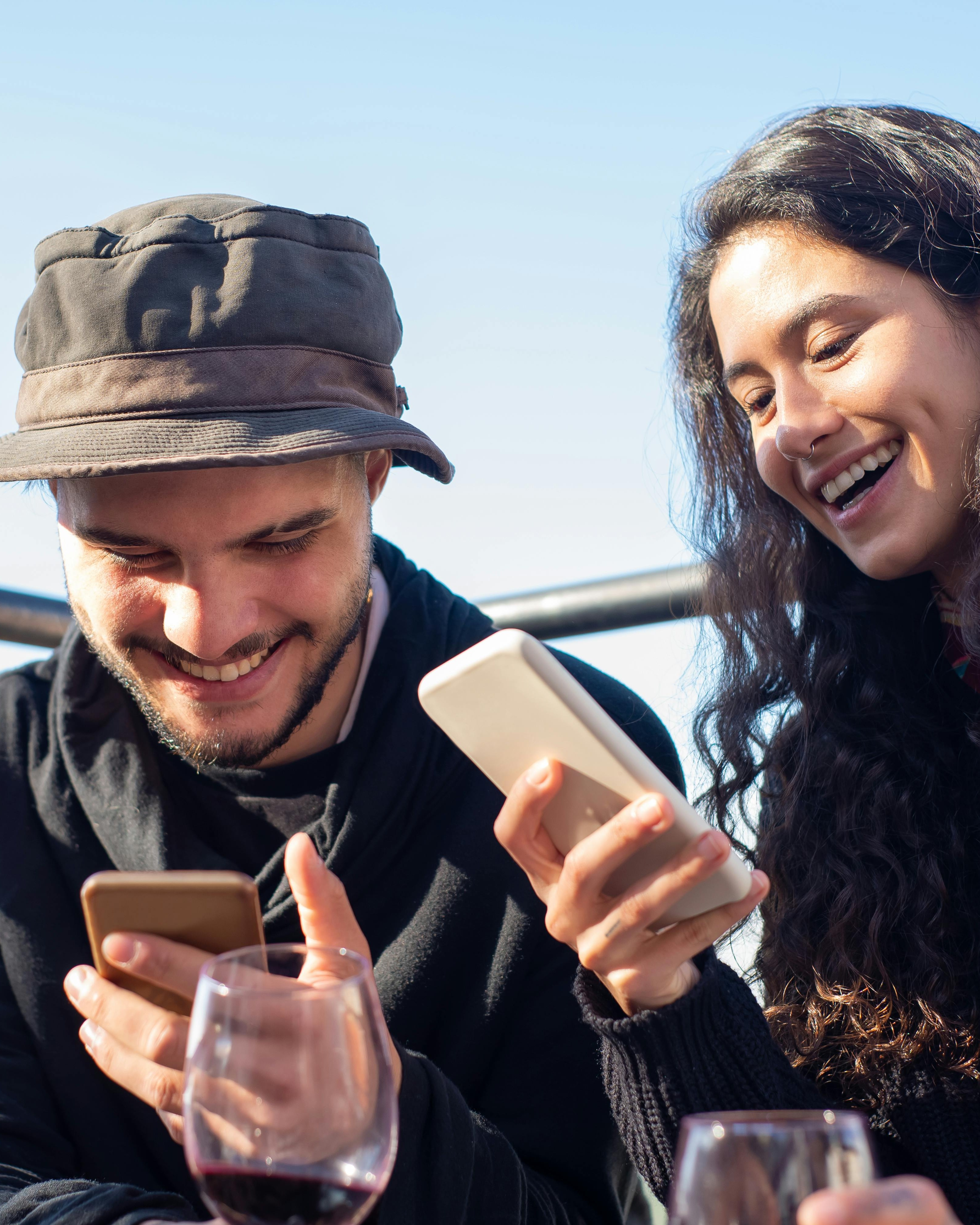 Two Happy Friends Using Phones Outdoors
