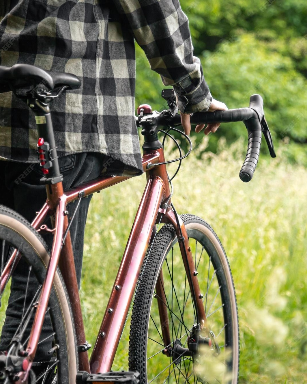 Cyclist With Bicycle in Grassy Field