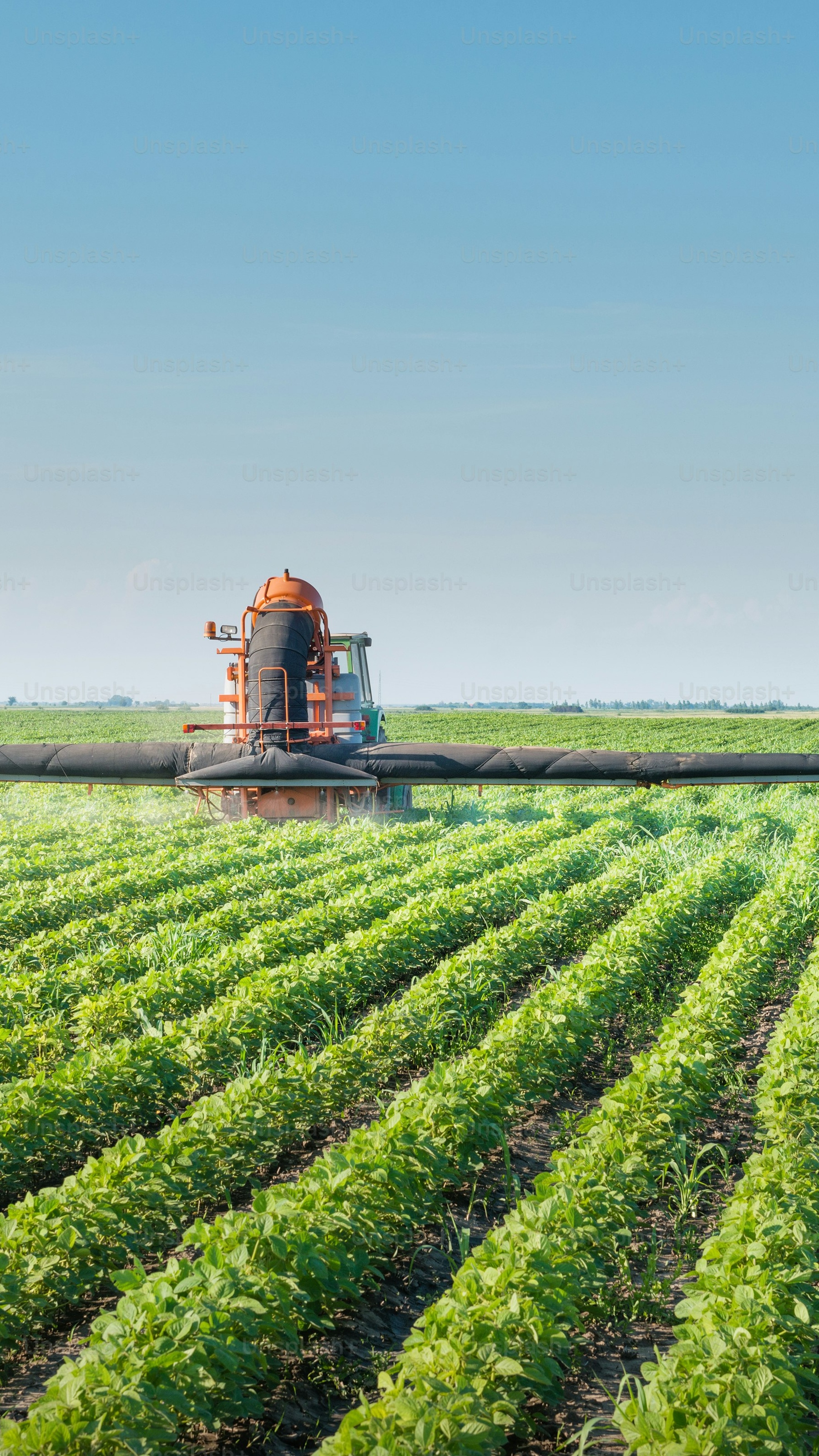 Tractor Spraying Crops in Farm Field