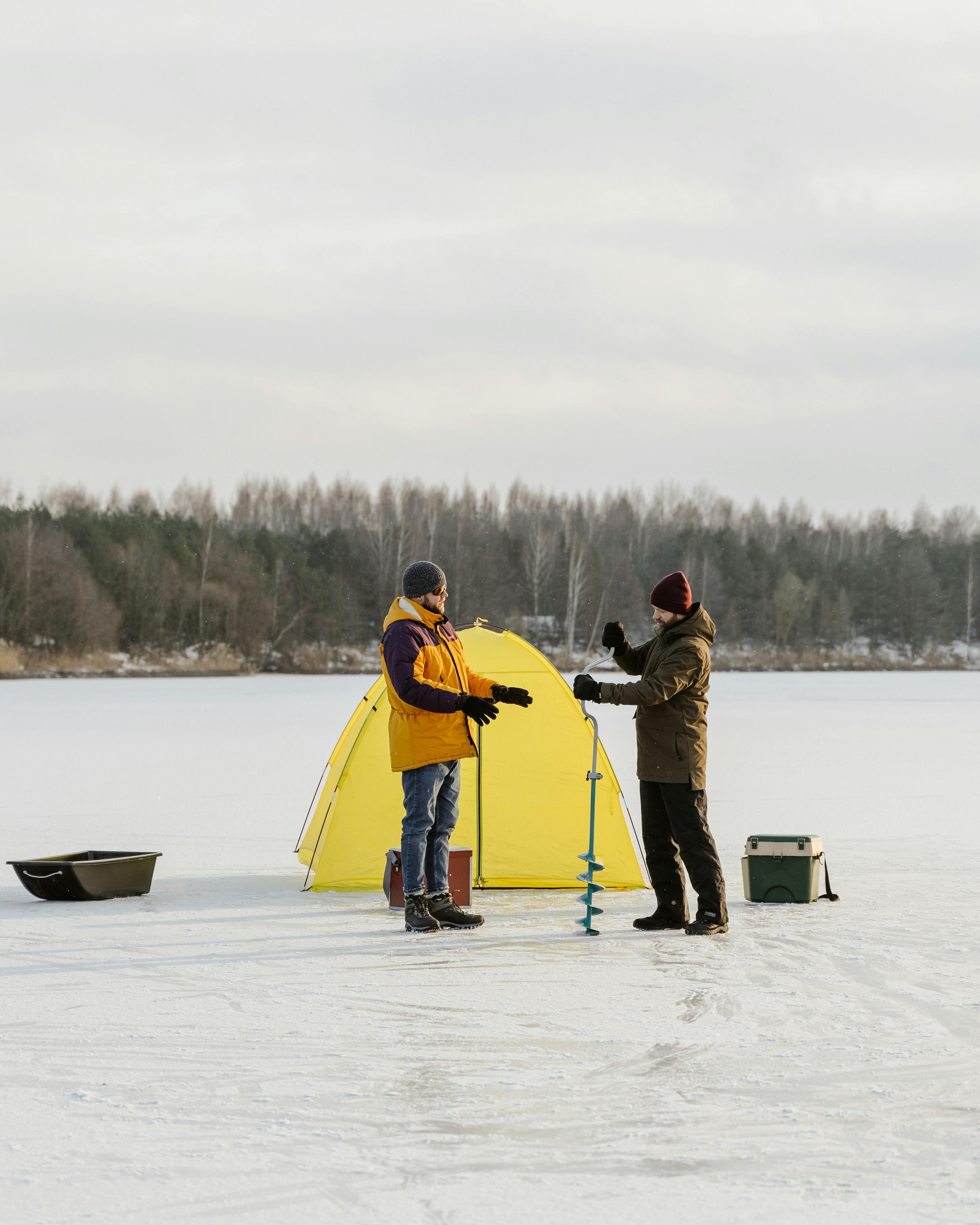 Two Men Ice Fishing on Frozen Lake
