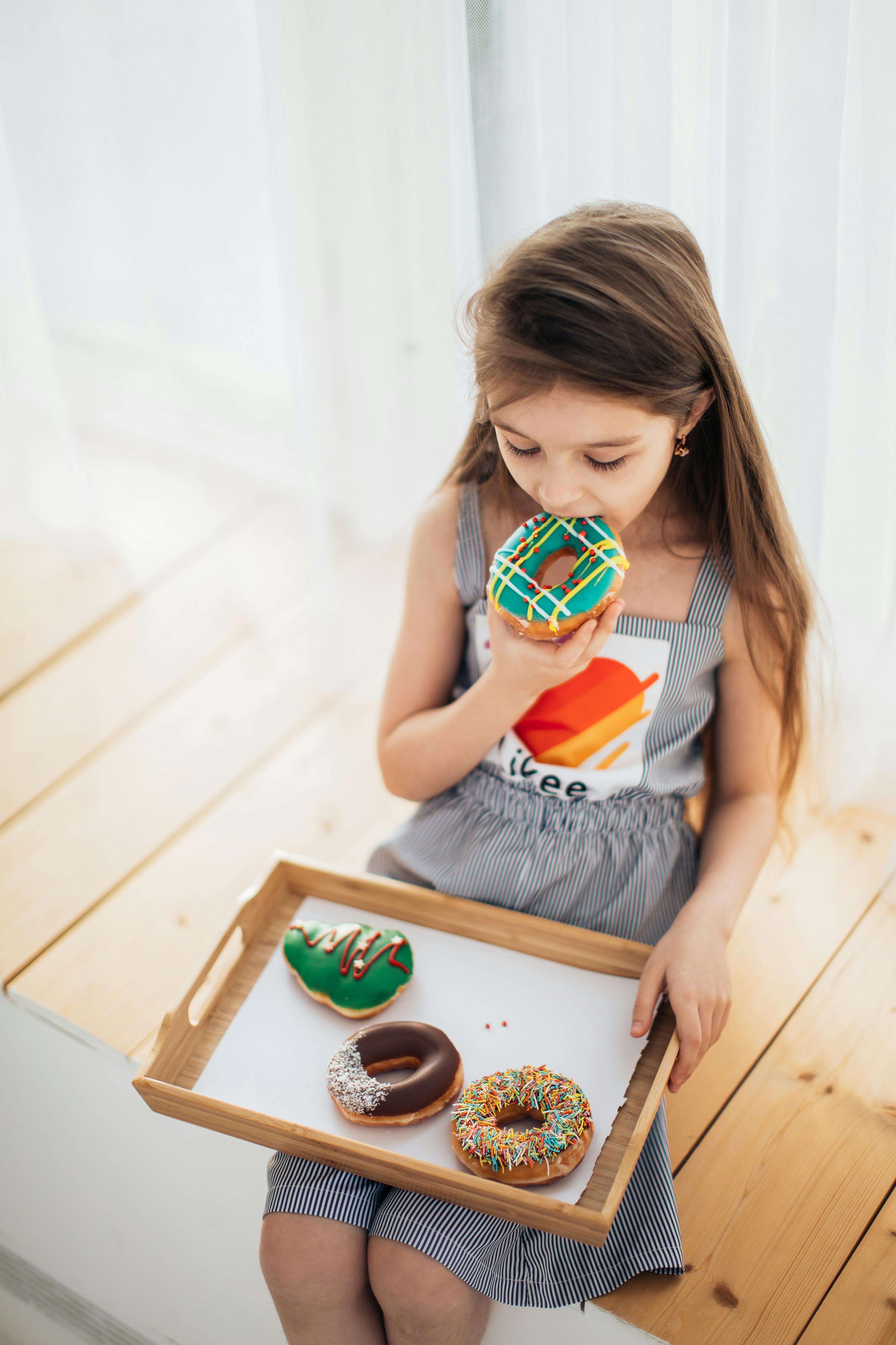 Little Girl Enjoying Colorful Donuts