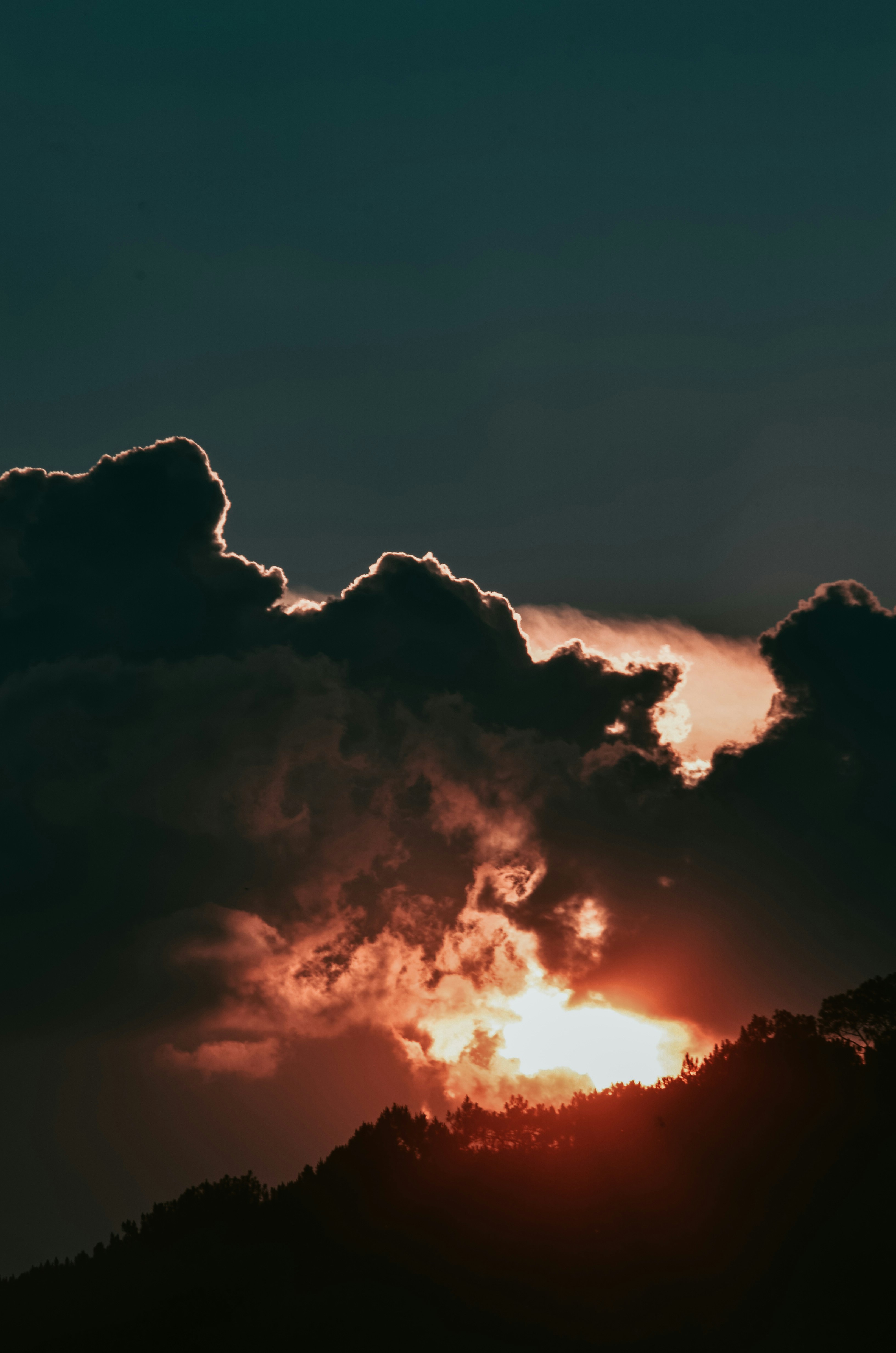 Sunset Behind Clouds Over Forest Hill