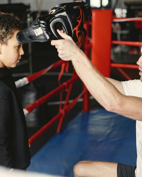 Coach Prepares Boy for Boxing Training