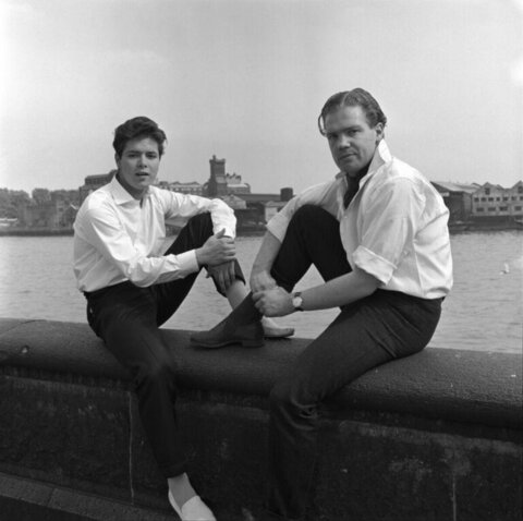 Two Men Sitting By The Riverside