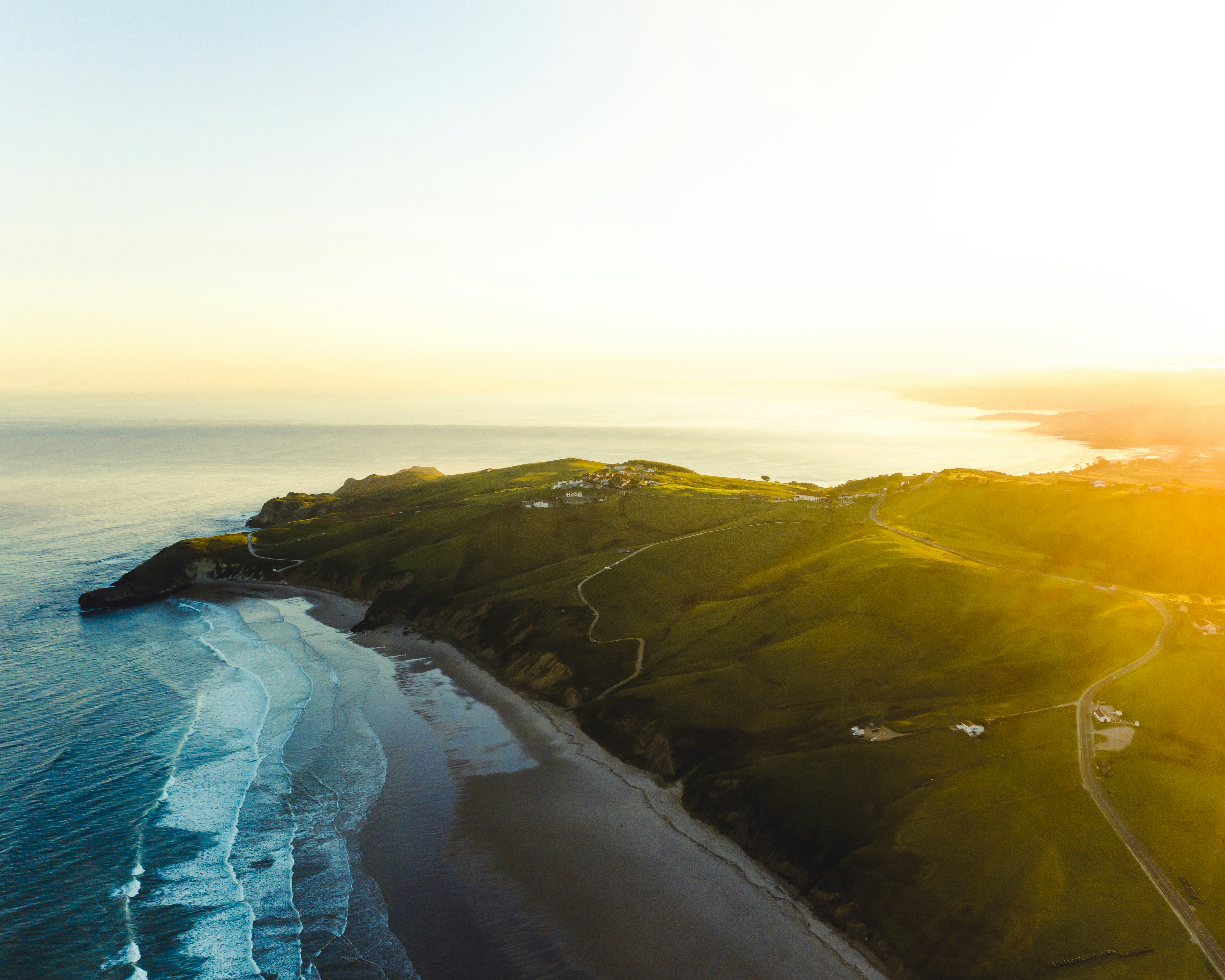 Aerial View of Sunlit Coastal Hillside Beach
