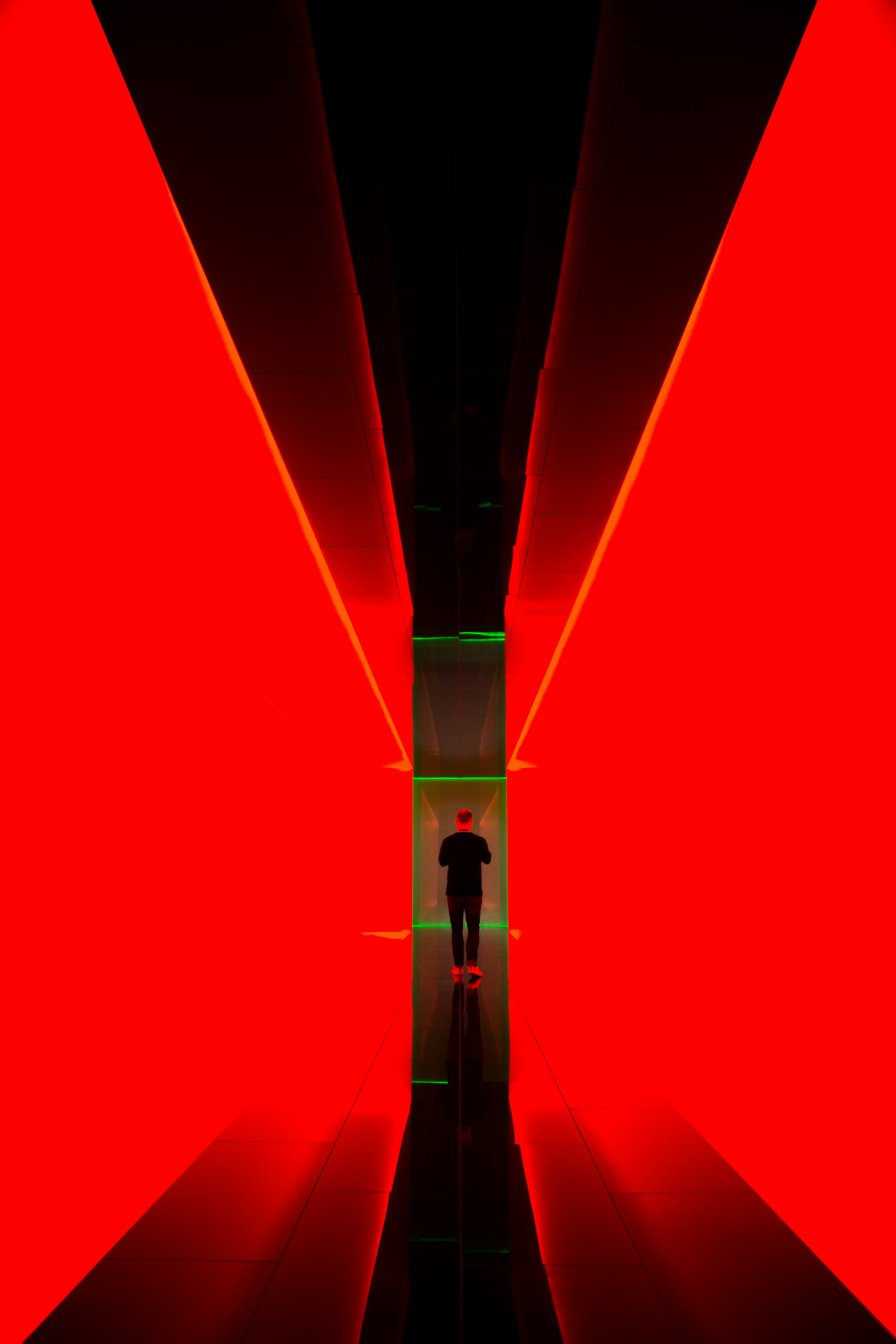 Man Standing in Red Neon Corridor