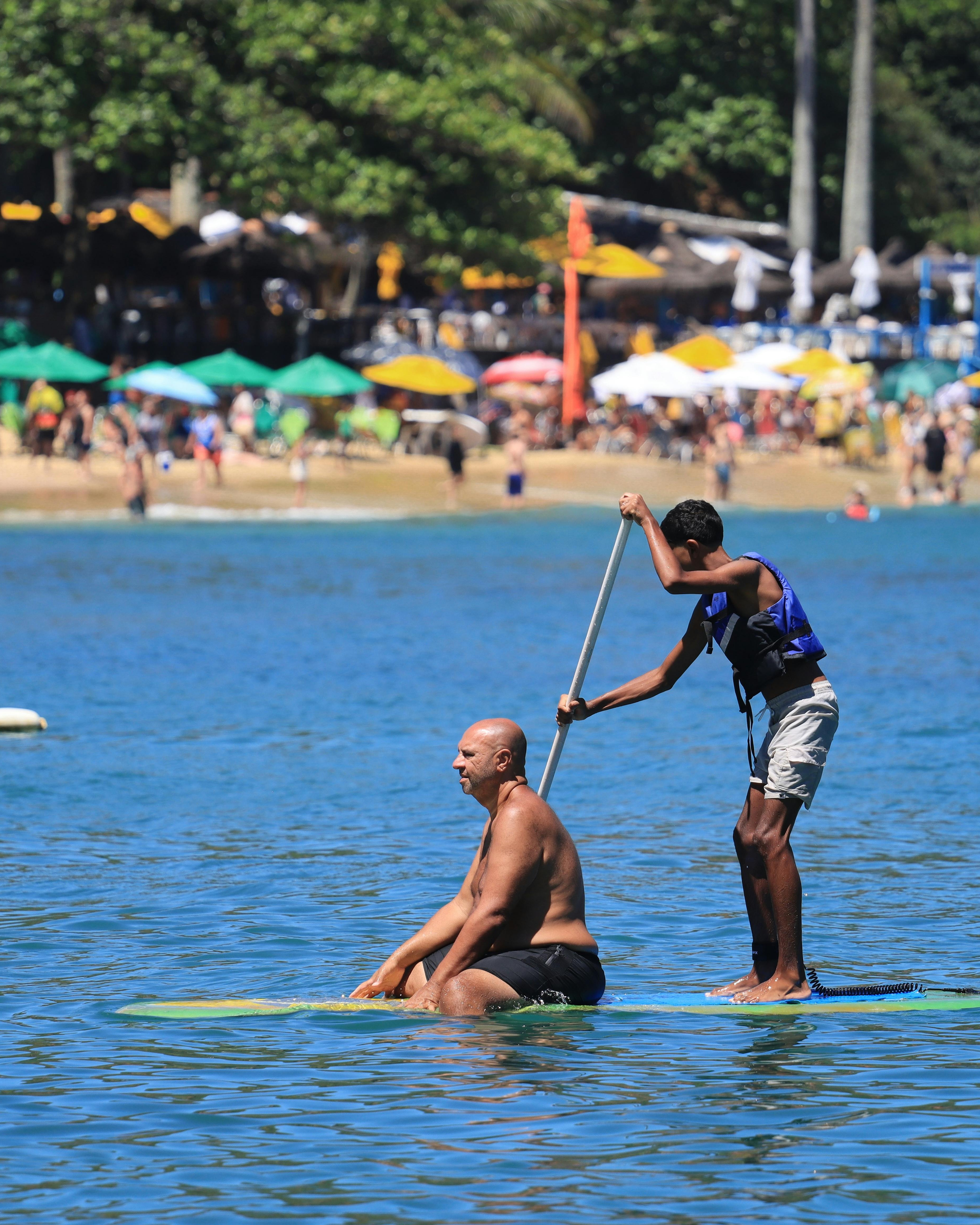 Two People Paddleboarding Near Beach