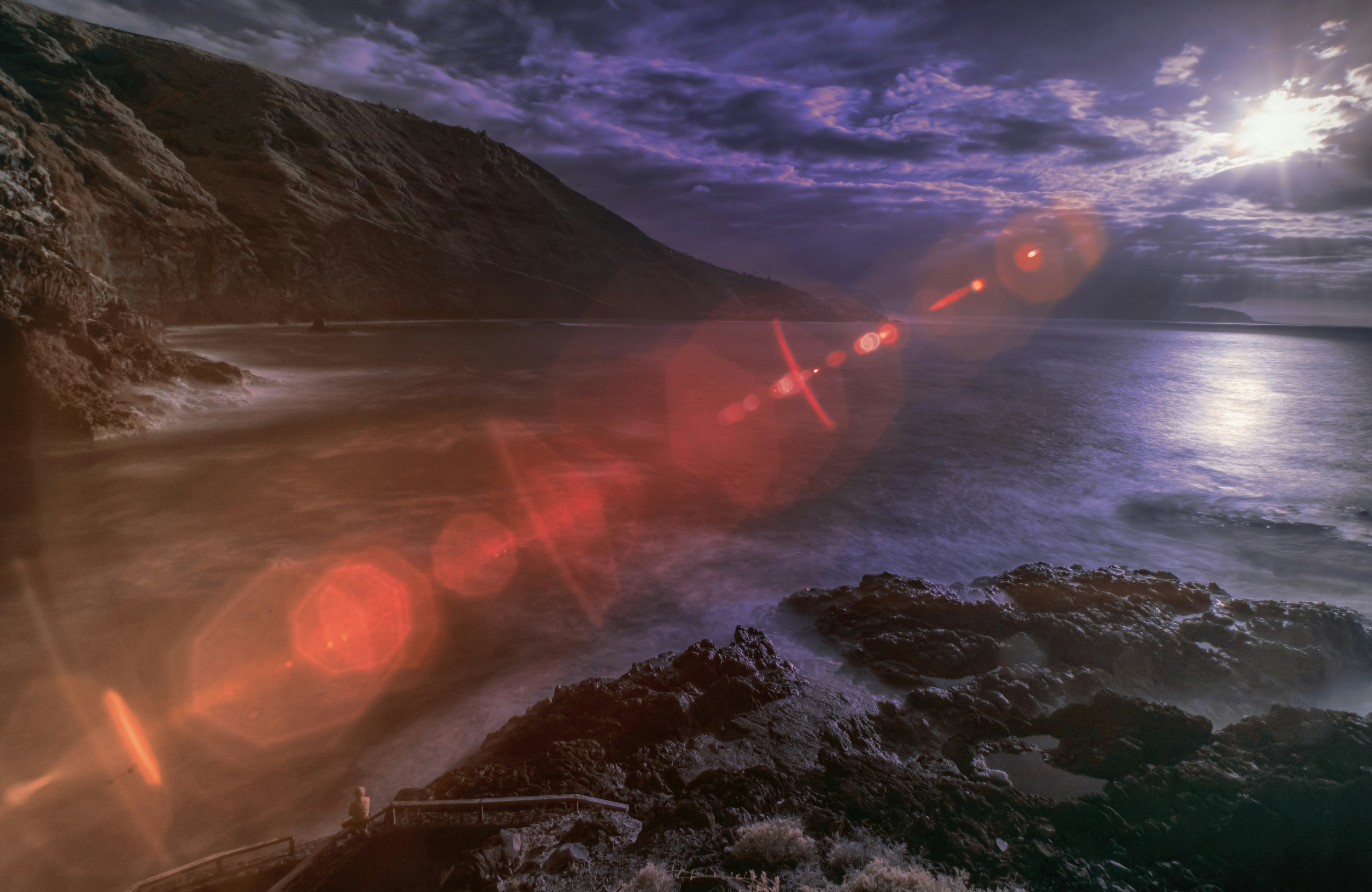 Coastal Sunset with Red Lens Flare