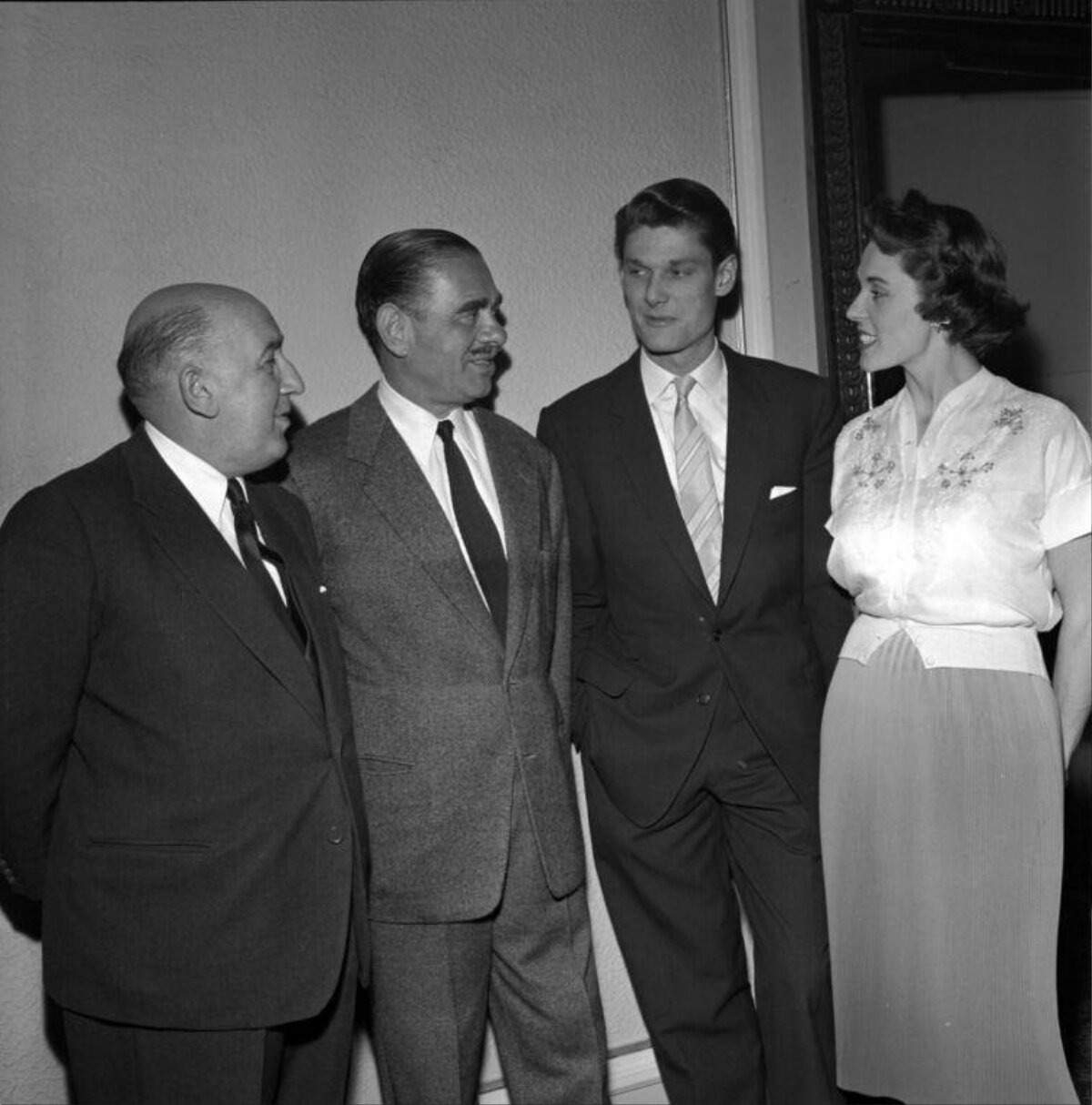 Four Formally Dressed People Standing Together