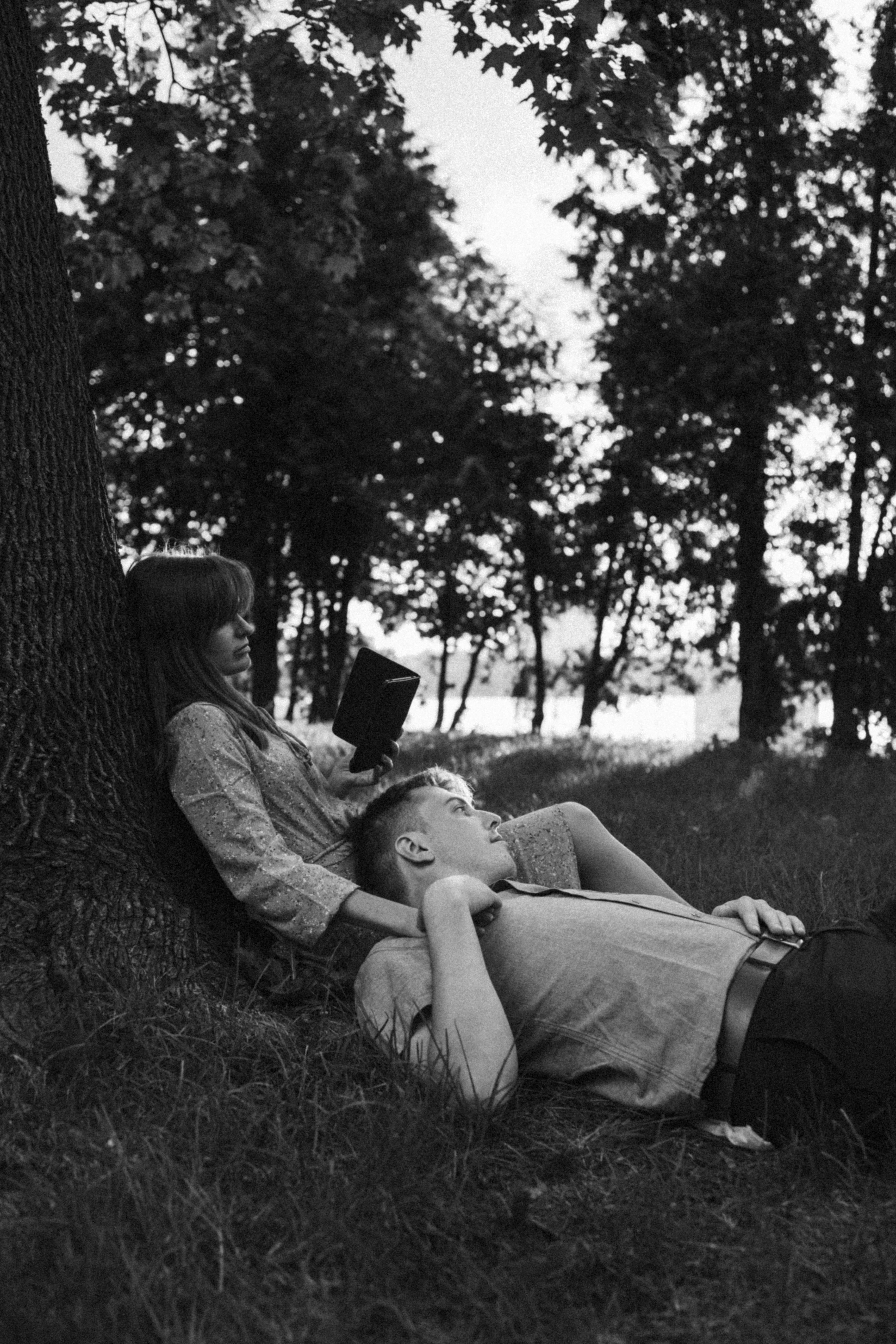 Couple relaxing under a tree outdoors
