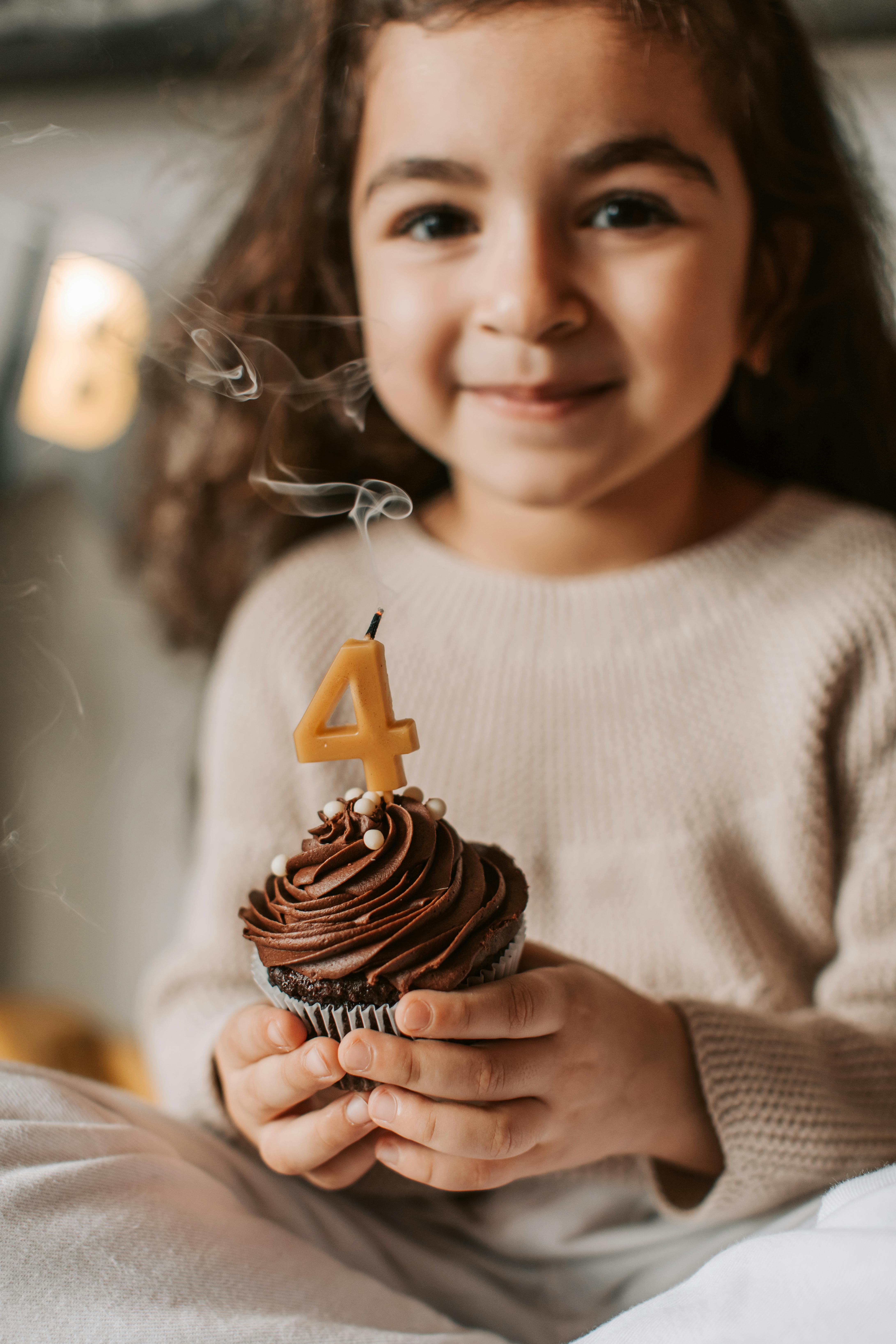 Girl Holding 4th Birthday Cupcake