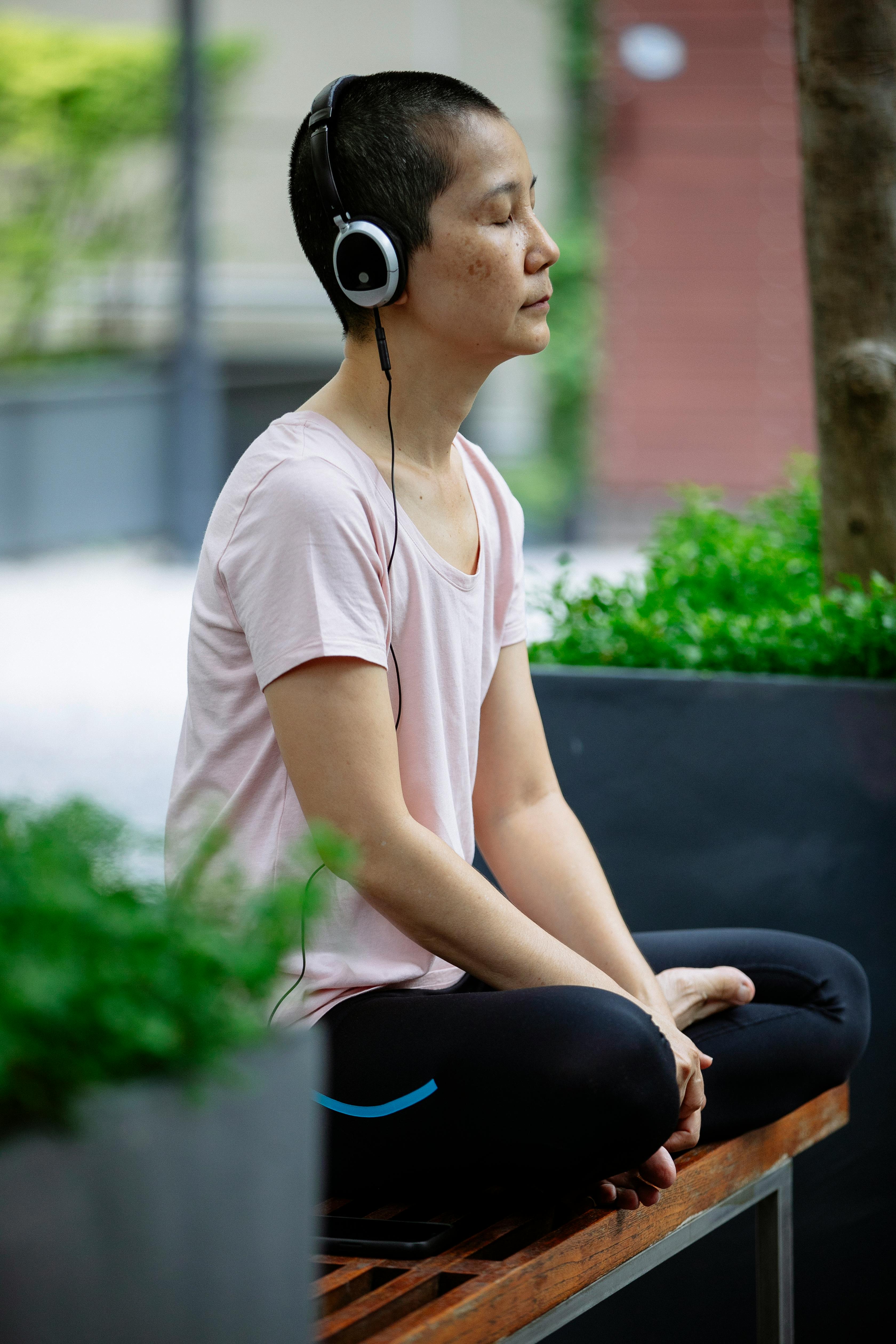 Woman Meditating Outdoors With Headphones
