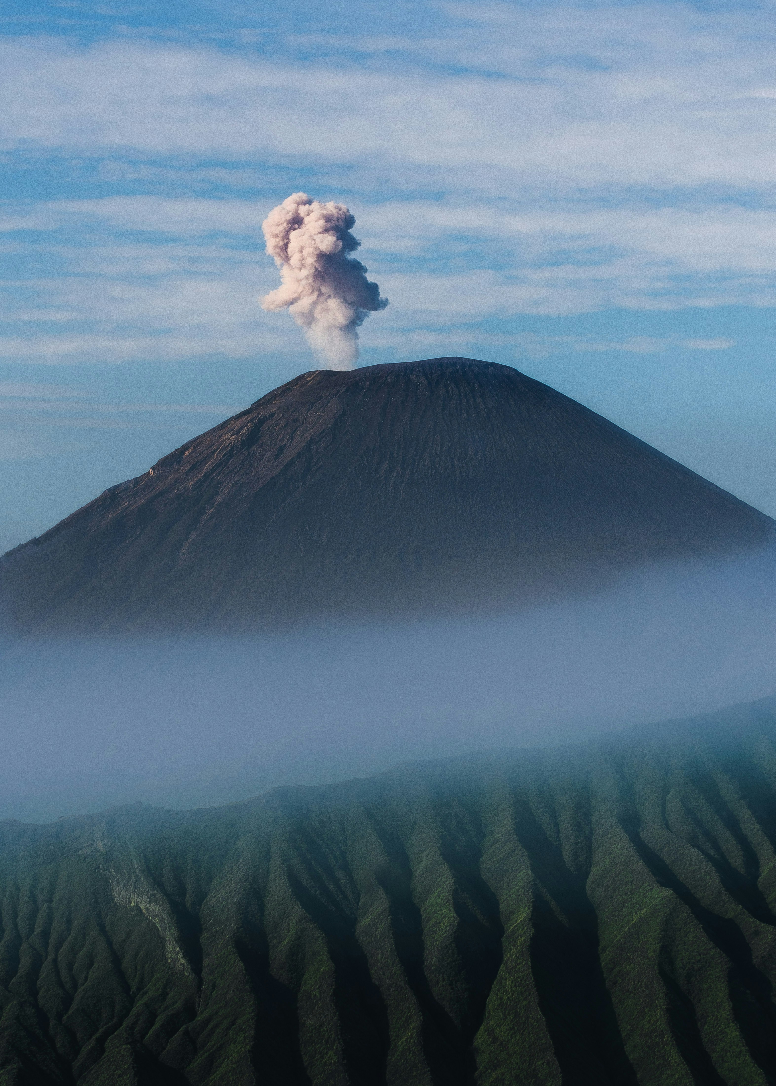 Erupting Volcano Above Sea of Clouds