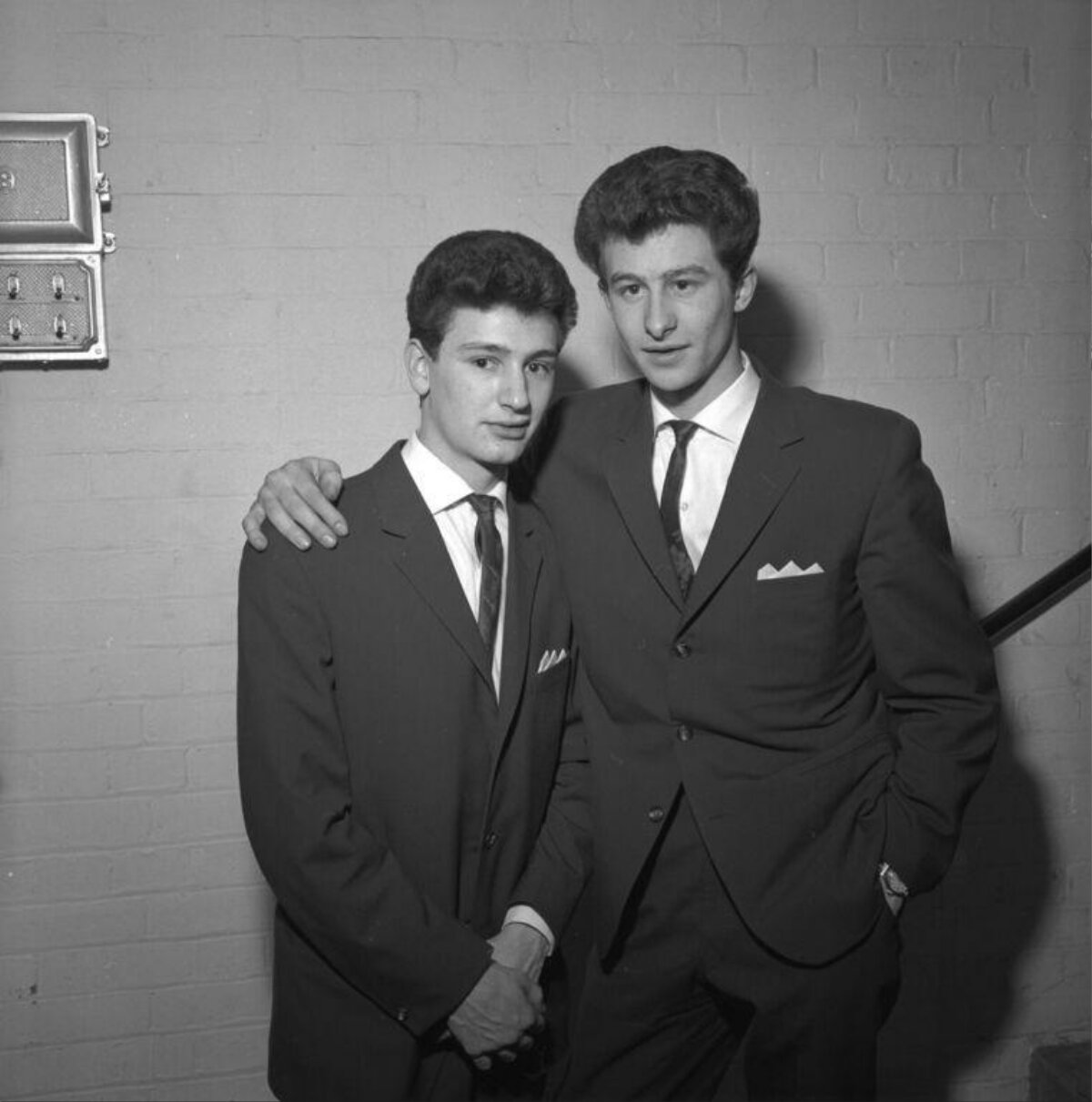 Two Young Men In Suits Posing