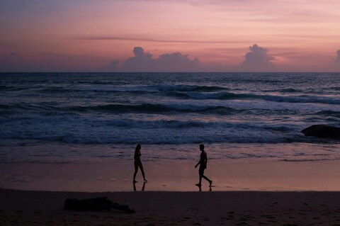 Couple Walking on Beach at Sunset