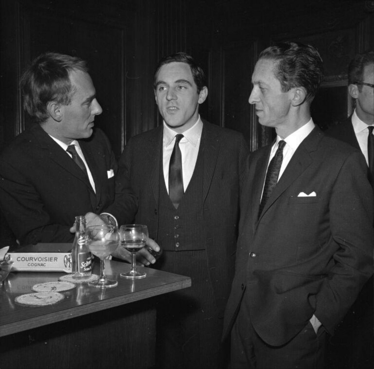 Three Men Chatting at a Bar Counter