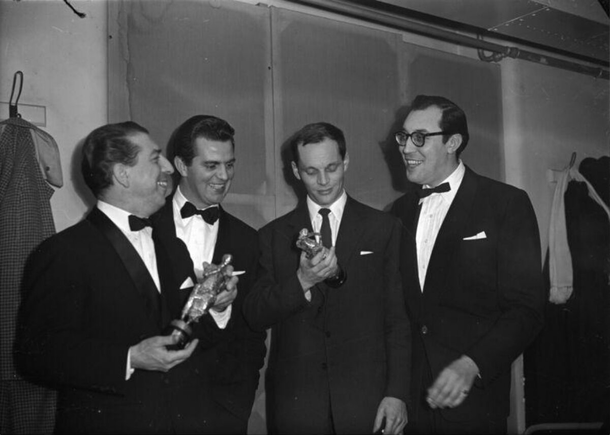 Four Men Holding Trophy Awards