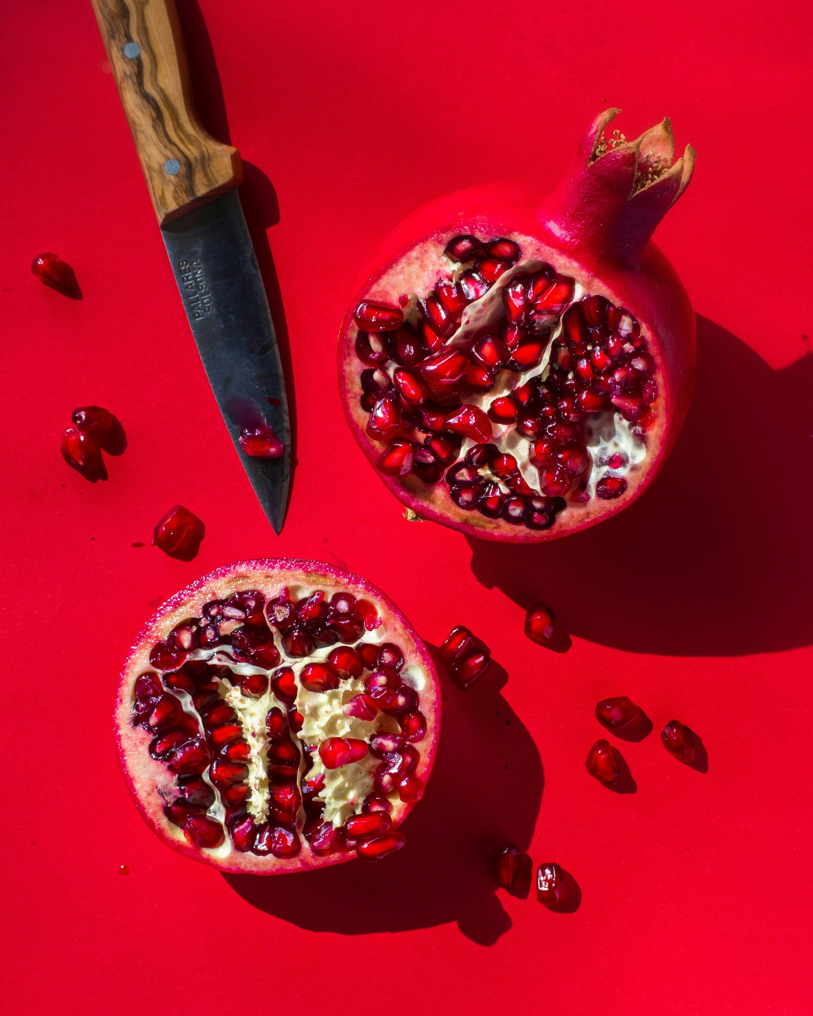 Halved Pomegranate on Red Background — Fruit Encyclopedia