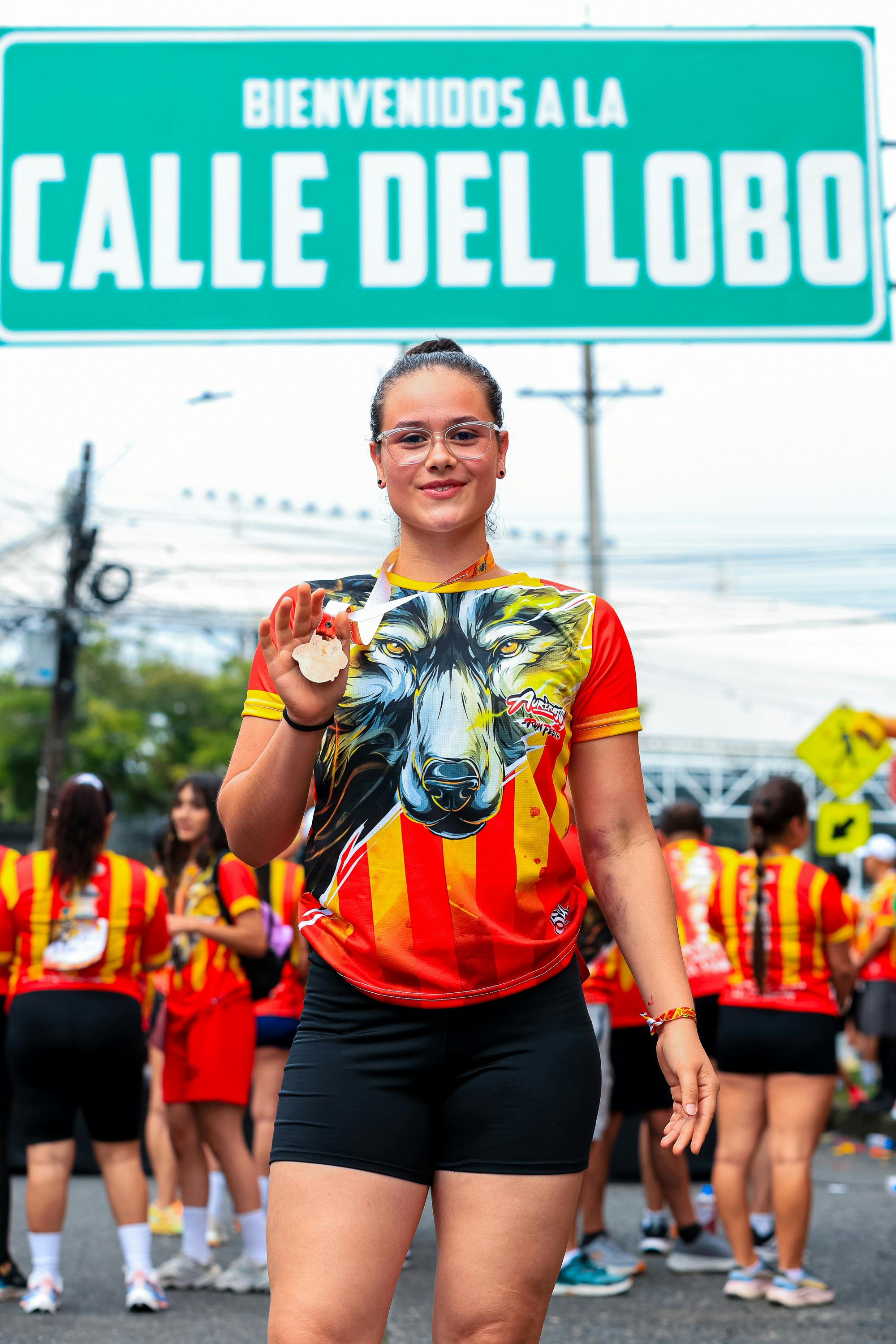 Young Runner Shows Medal at Calle del Lobo