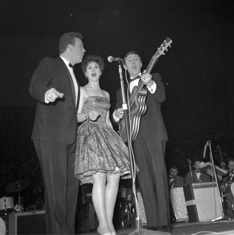 Three Singers Performing On Stage