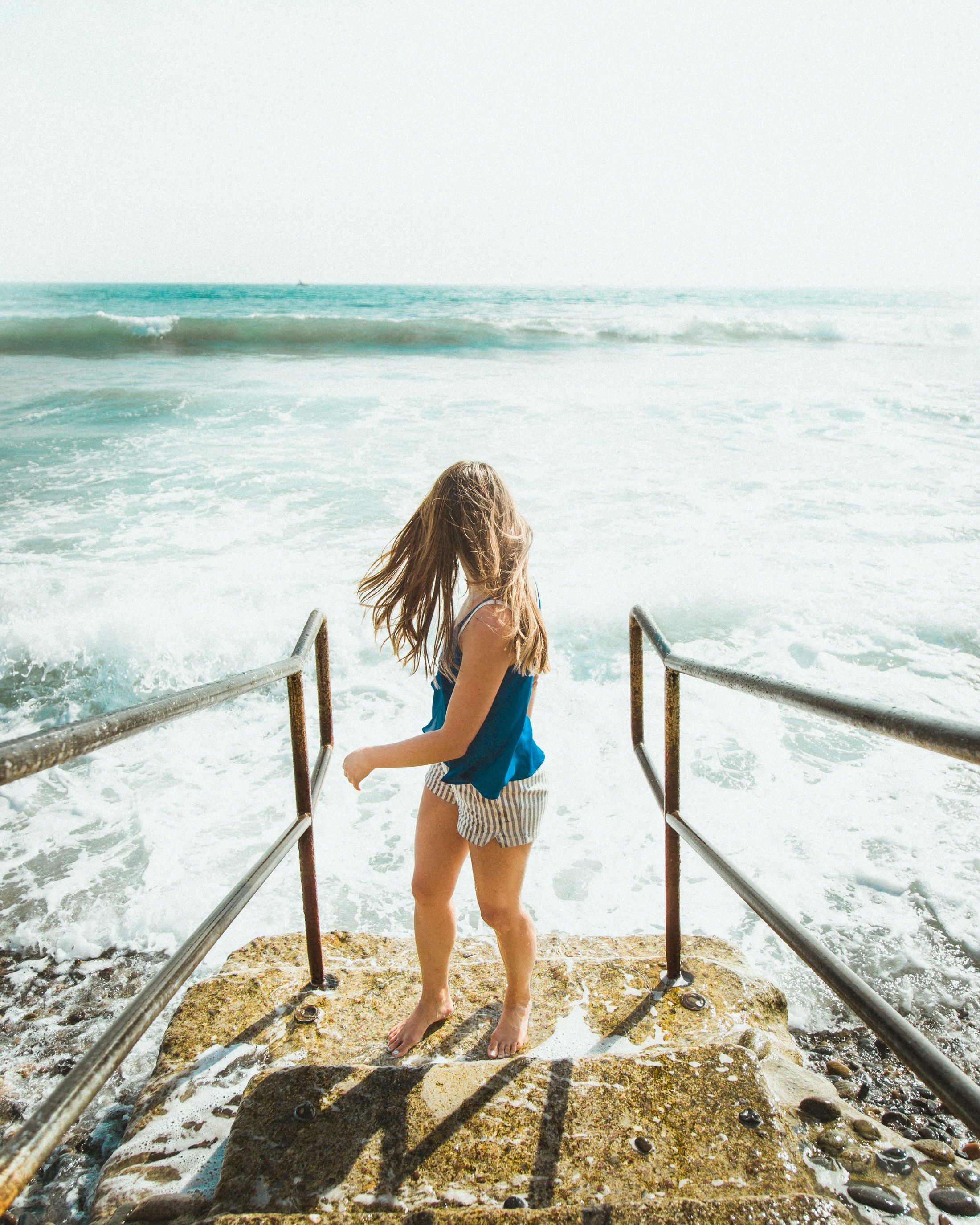 Girl on Stairs Facing Ocean