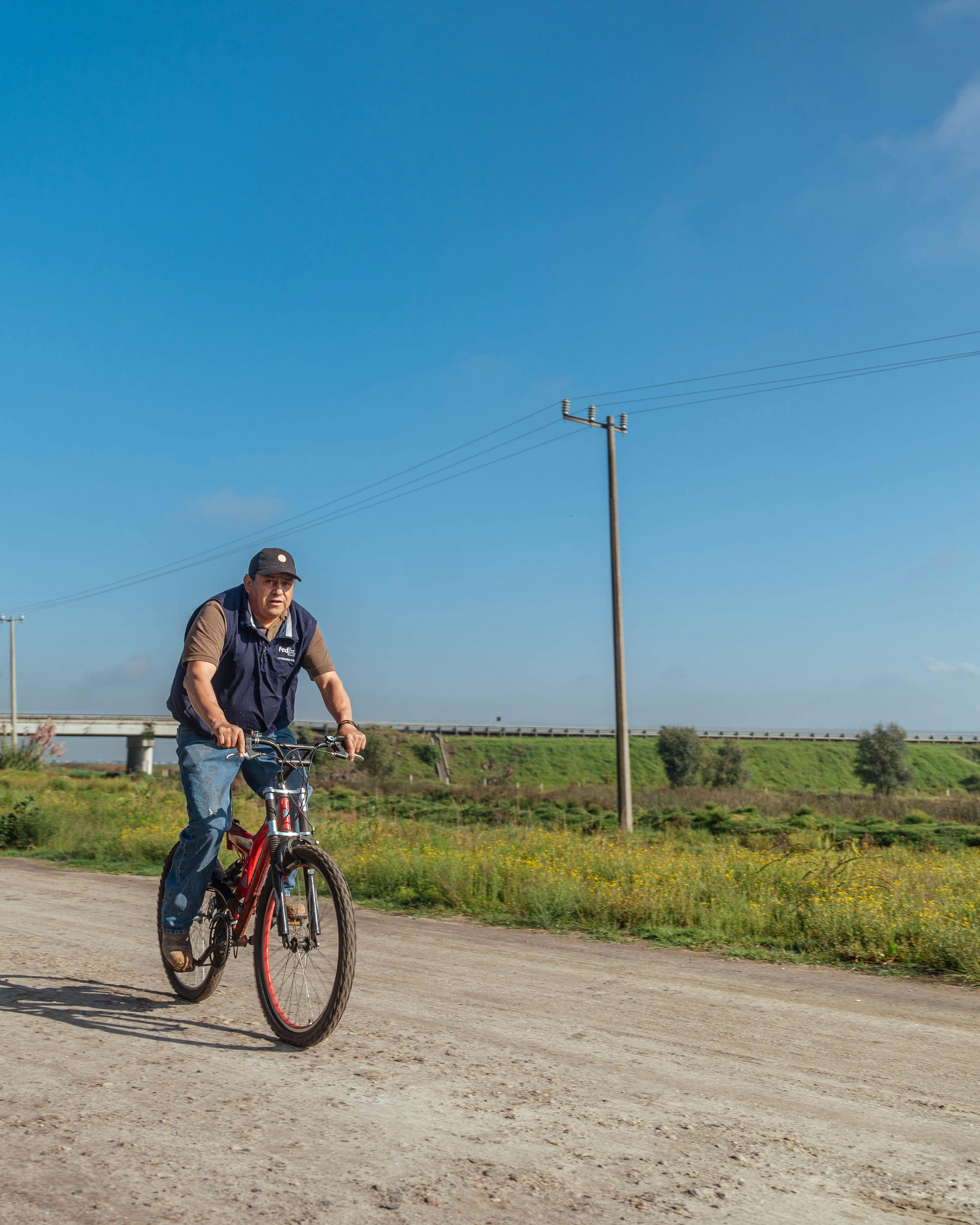 Man Cycling on Rural Dirt Road