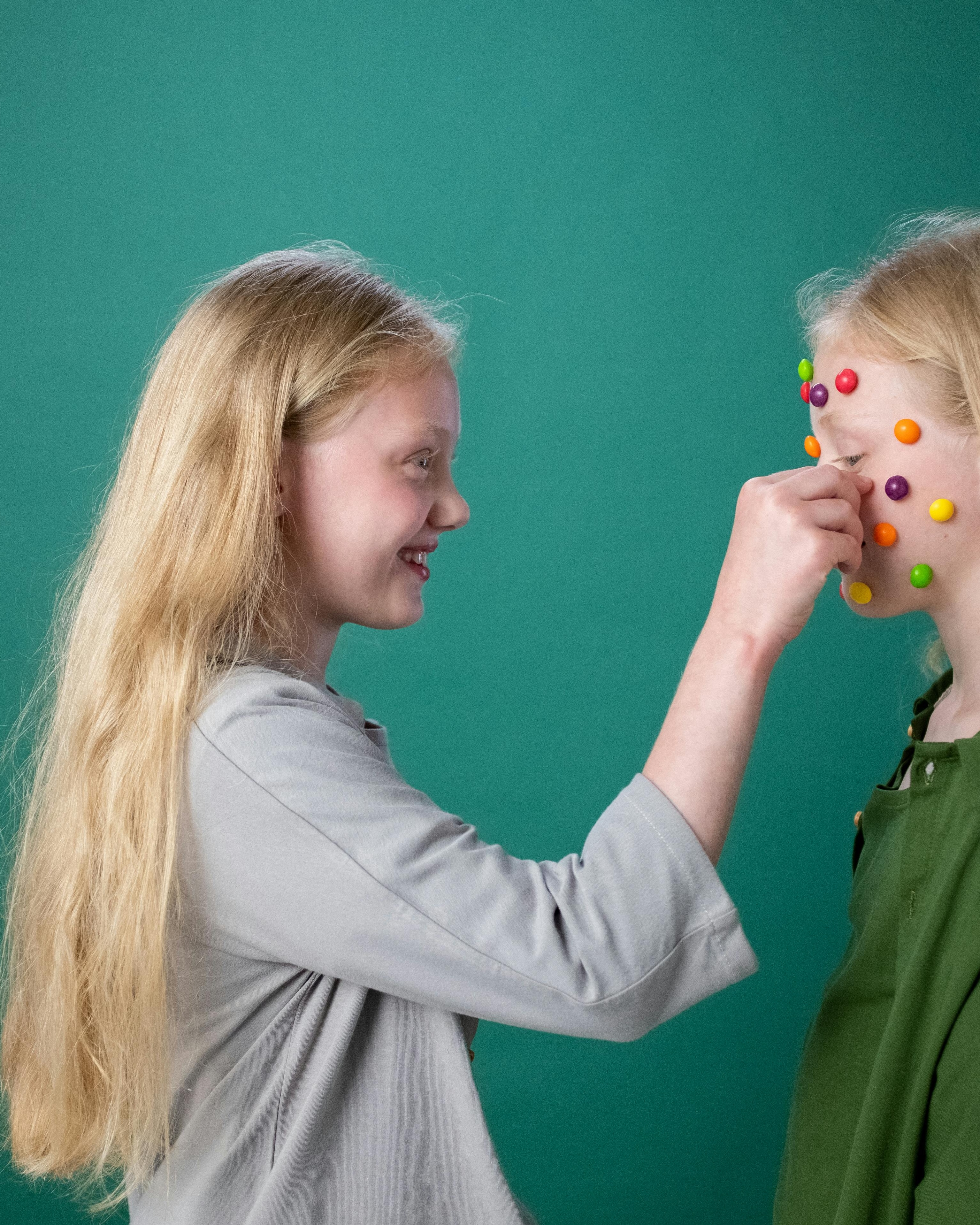 Girl Places Candy Dots On Another Girl's Face