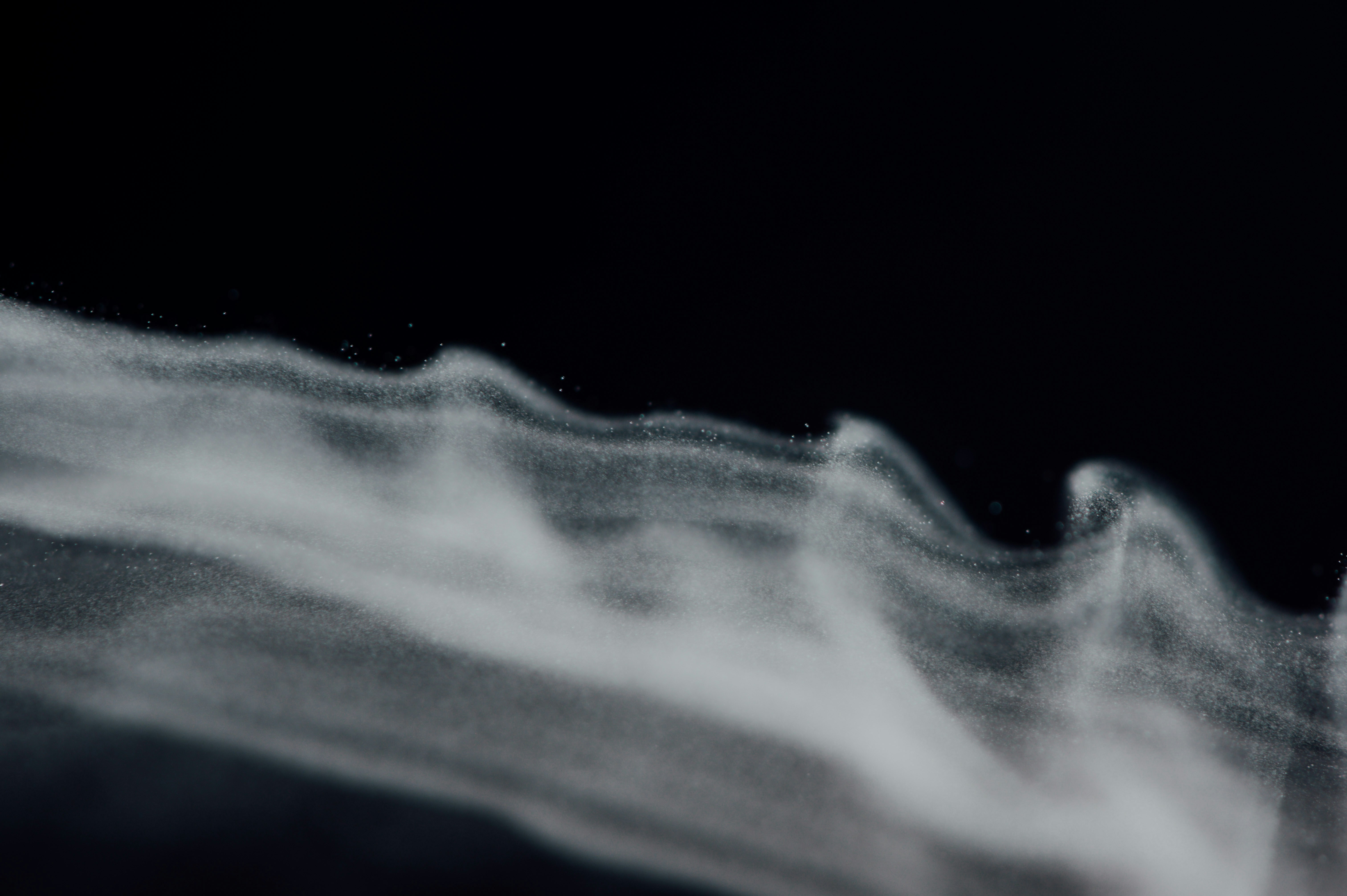Flowing White Powder Against Black Background