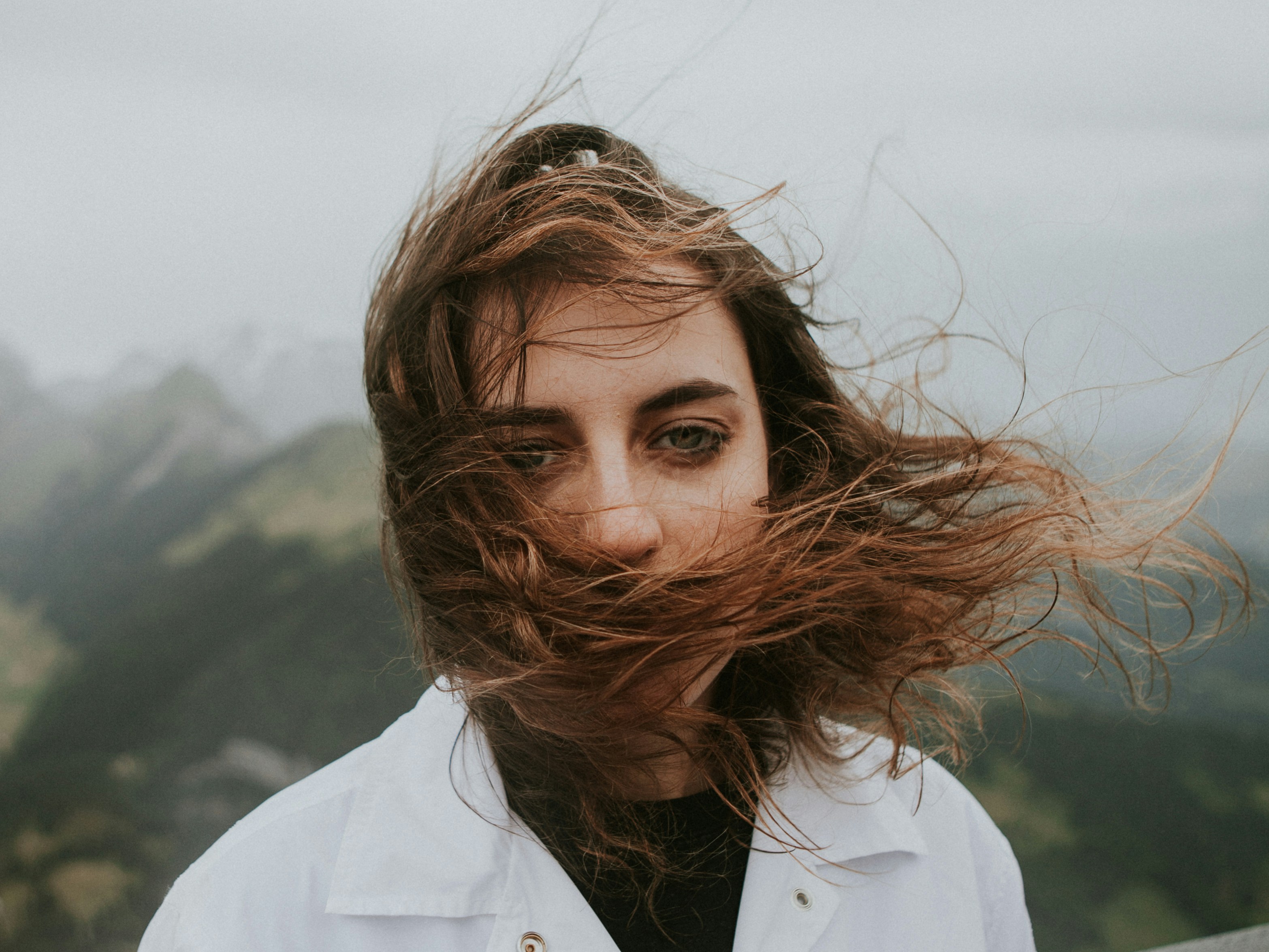 Woman With Windblown Hair In Mountains