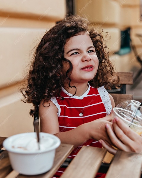 Young Girl at Outdoor Cafe Table