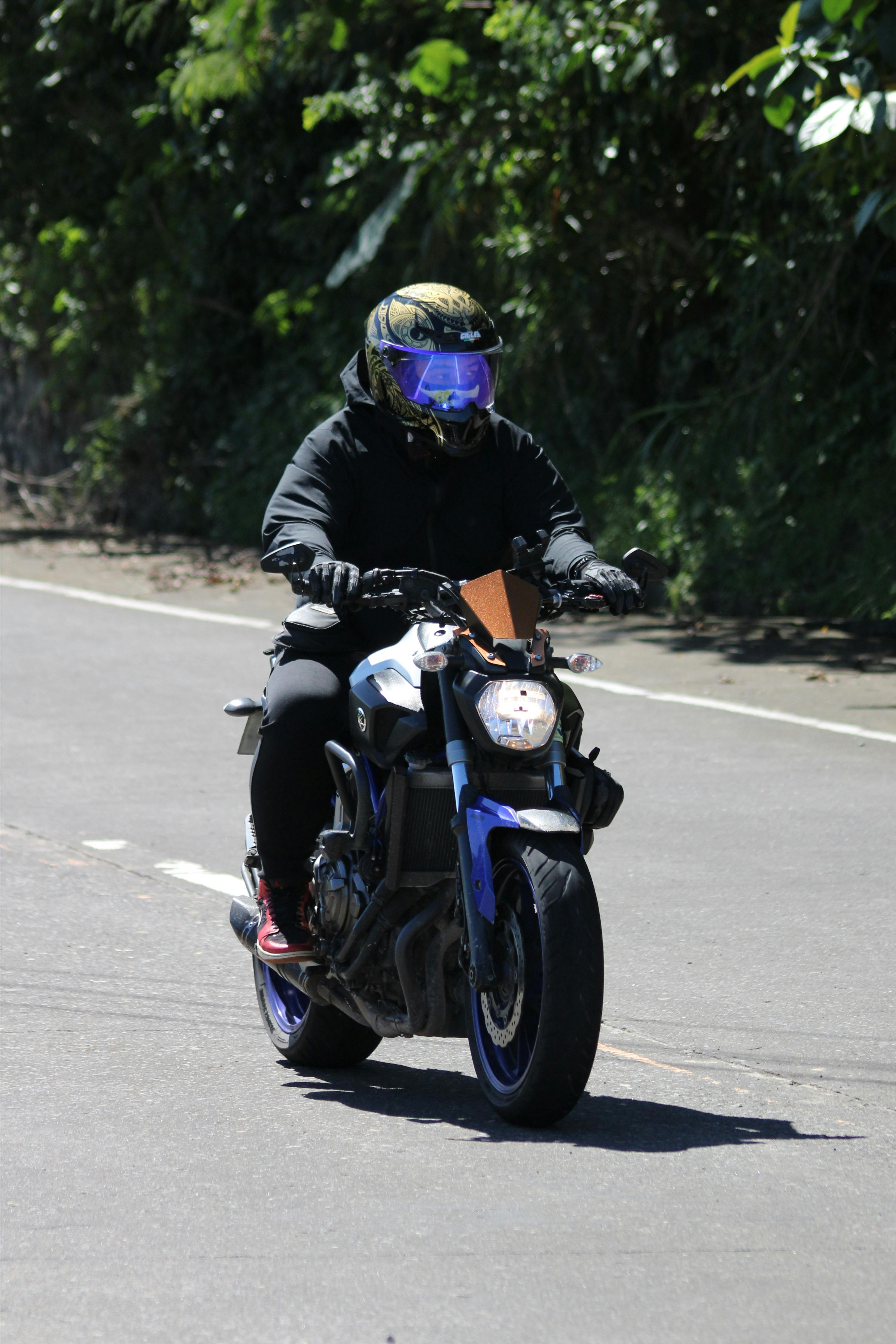 Motorcyclist Riding Motorcycle on Paved Road