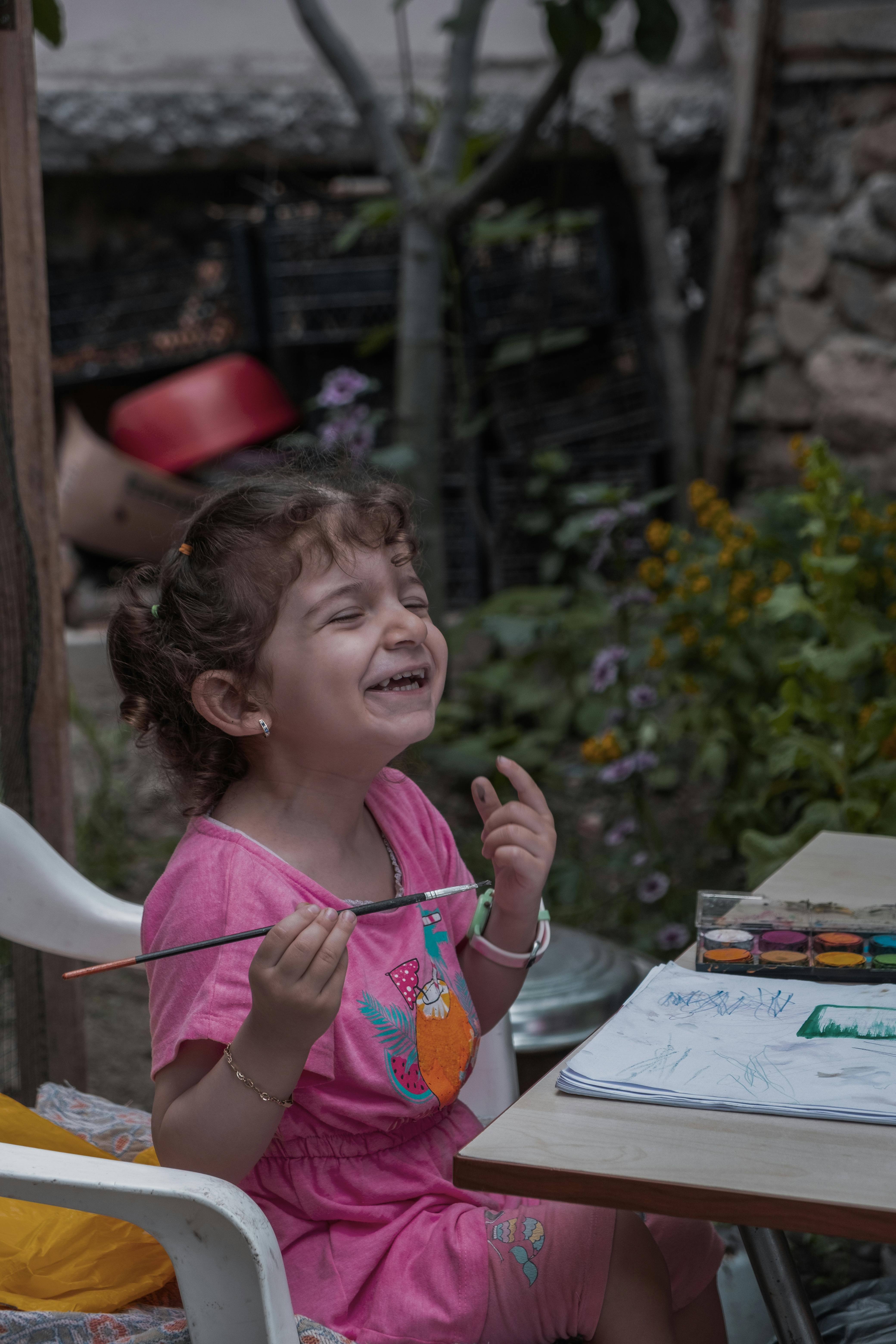 Laughing Little Girl Painting Outdoors