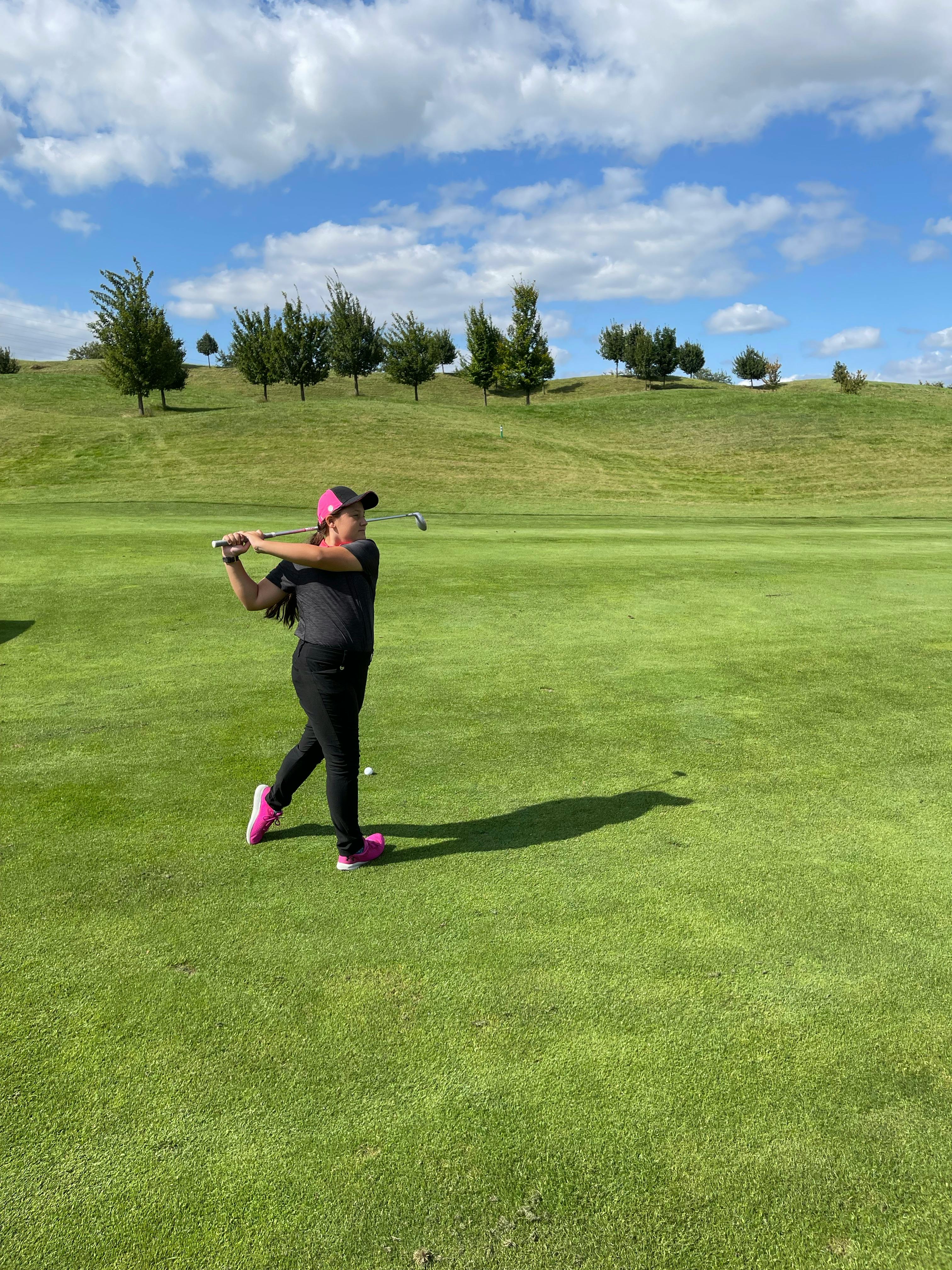Woman Mid-Swing on Golf Course