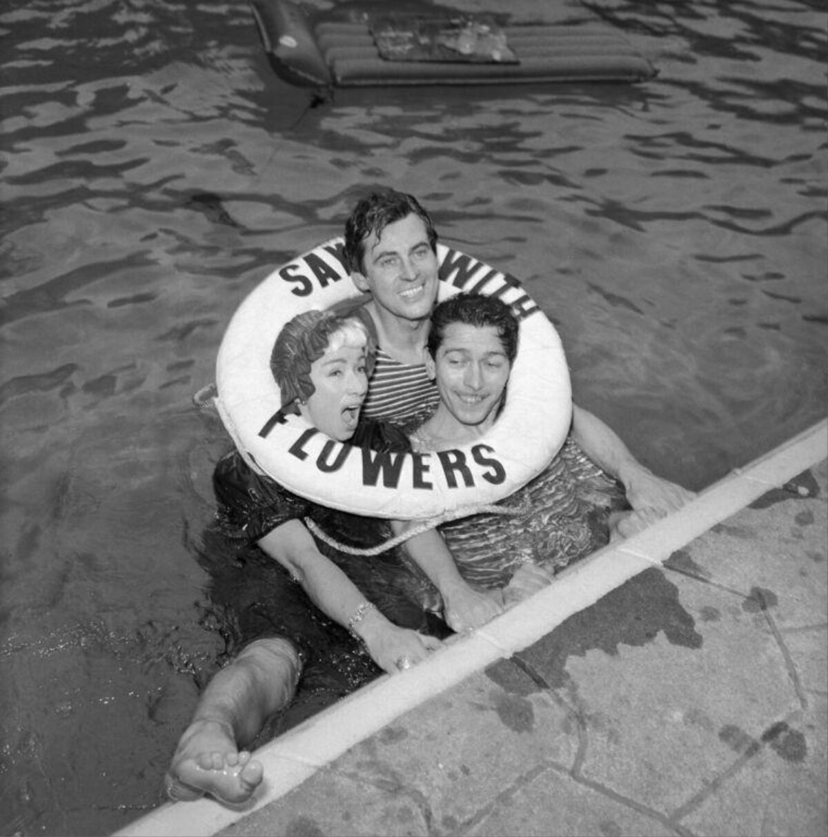Three People in Pool With Life Ring