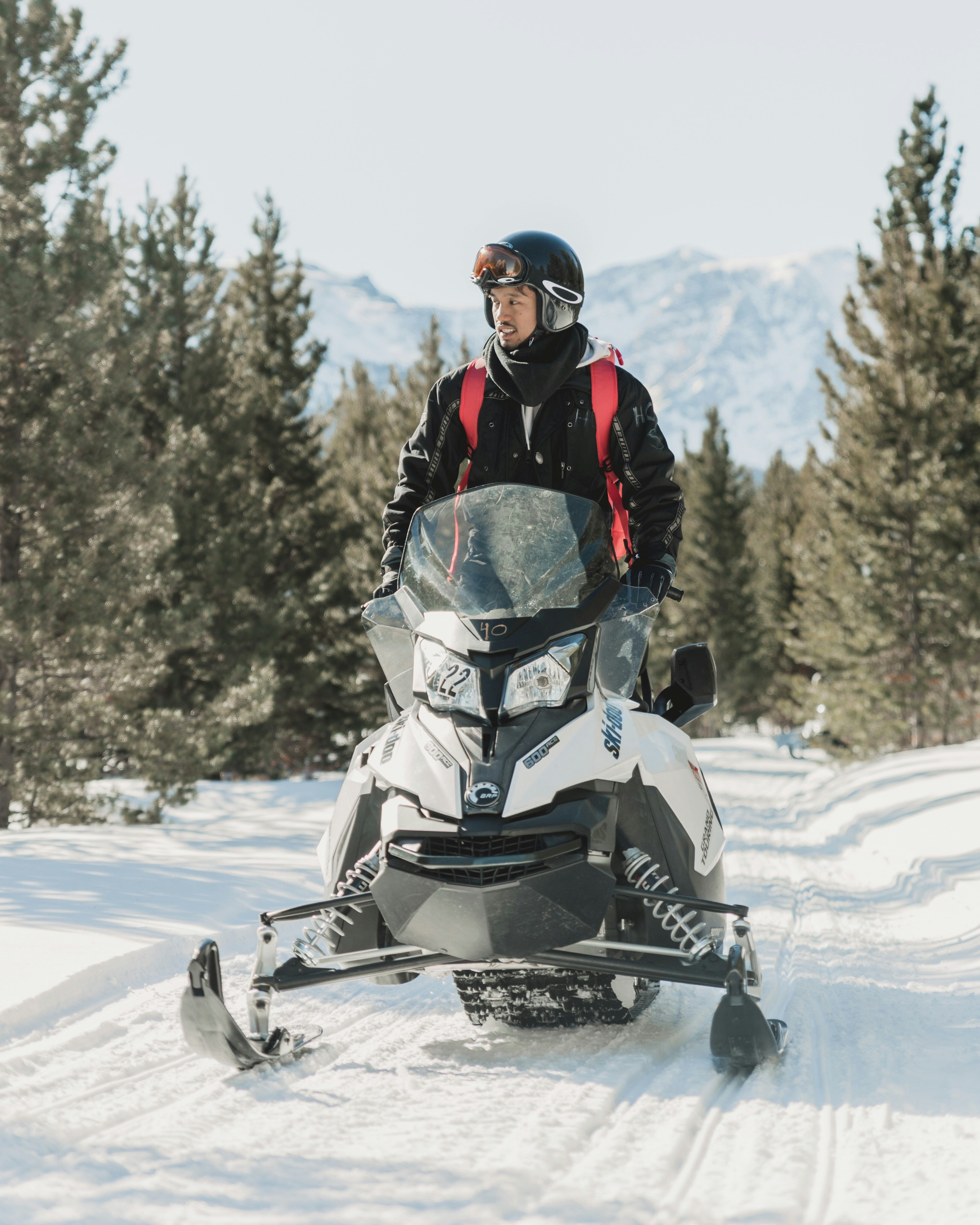 Man Riding Snowmobile on Snow Trail