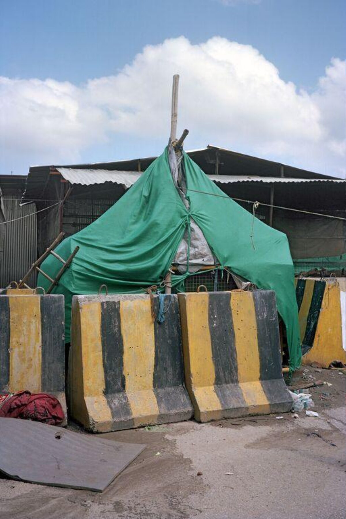 Makeshift Green Tent Behind Road Barriers