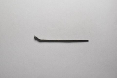 Bent Metal Tool on Plain Gray Background