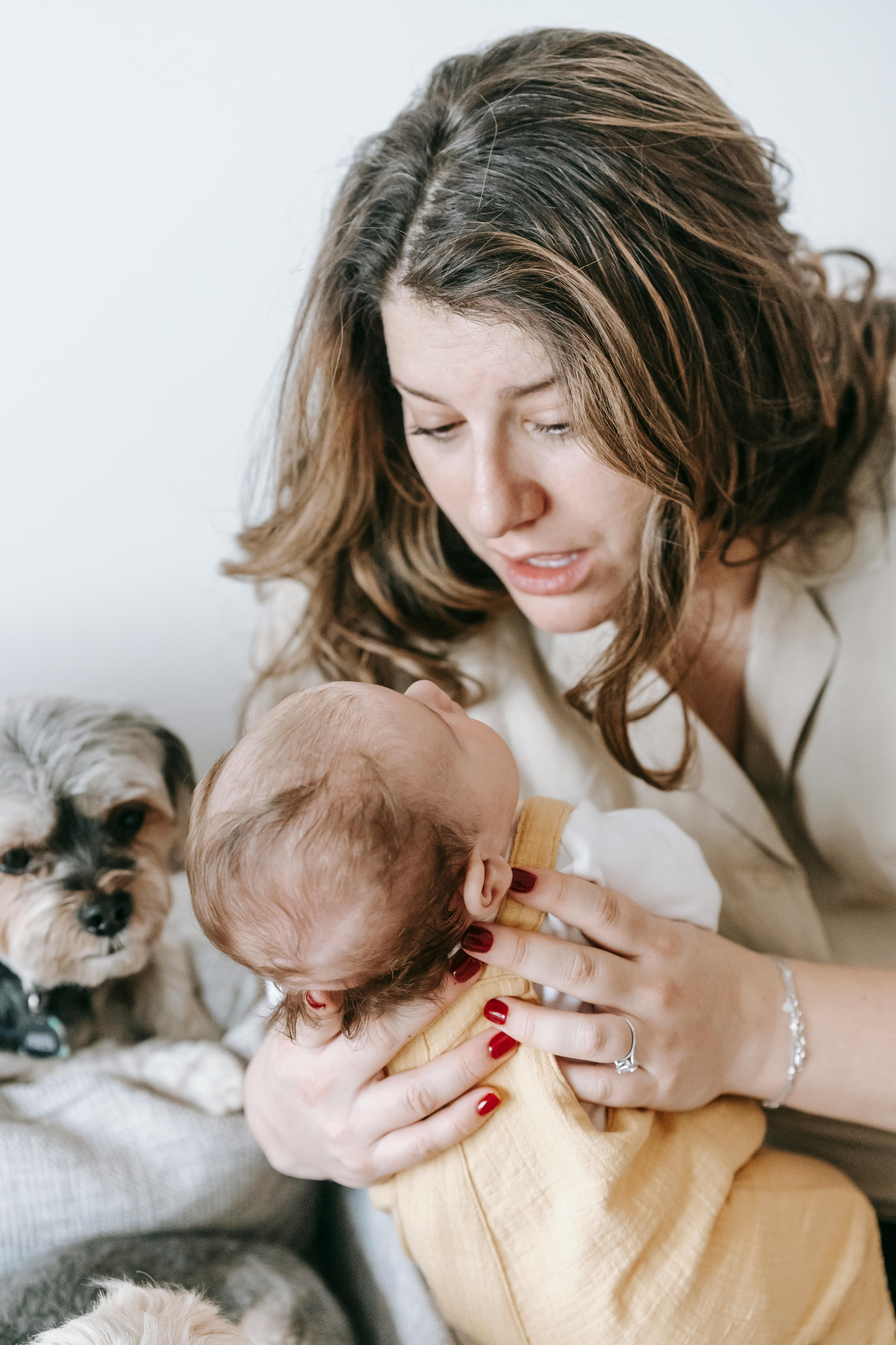 Mother Holding Baby With Family Dog