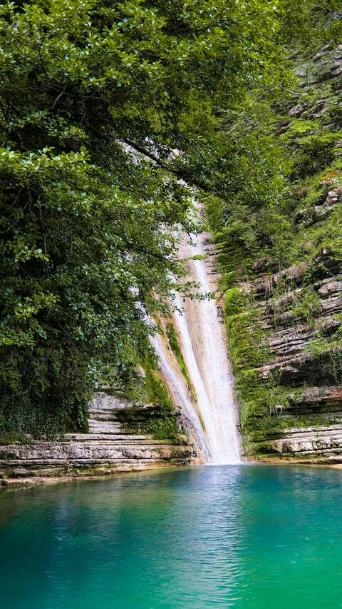Waterfall Flowing Into Turquoise Pool