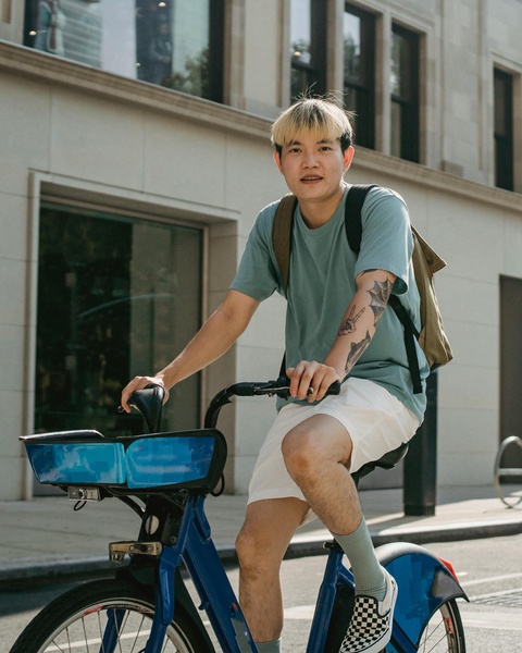 Young Man Riding Bicycle on City Street