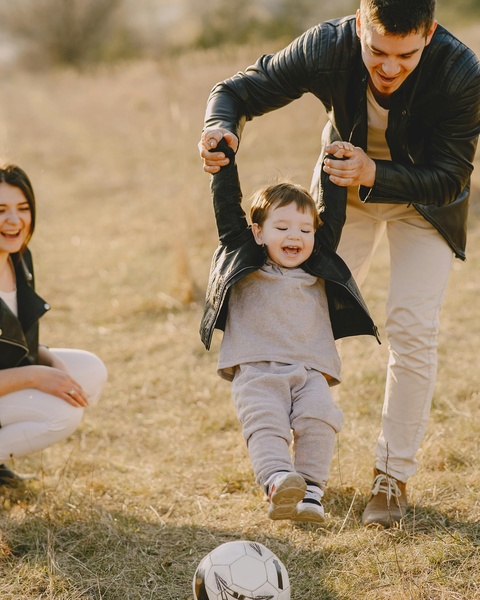 Happy Family Playing With Toddler Outdoors